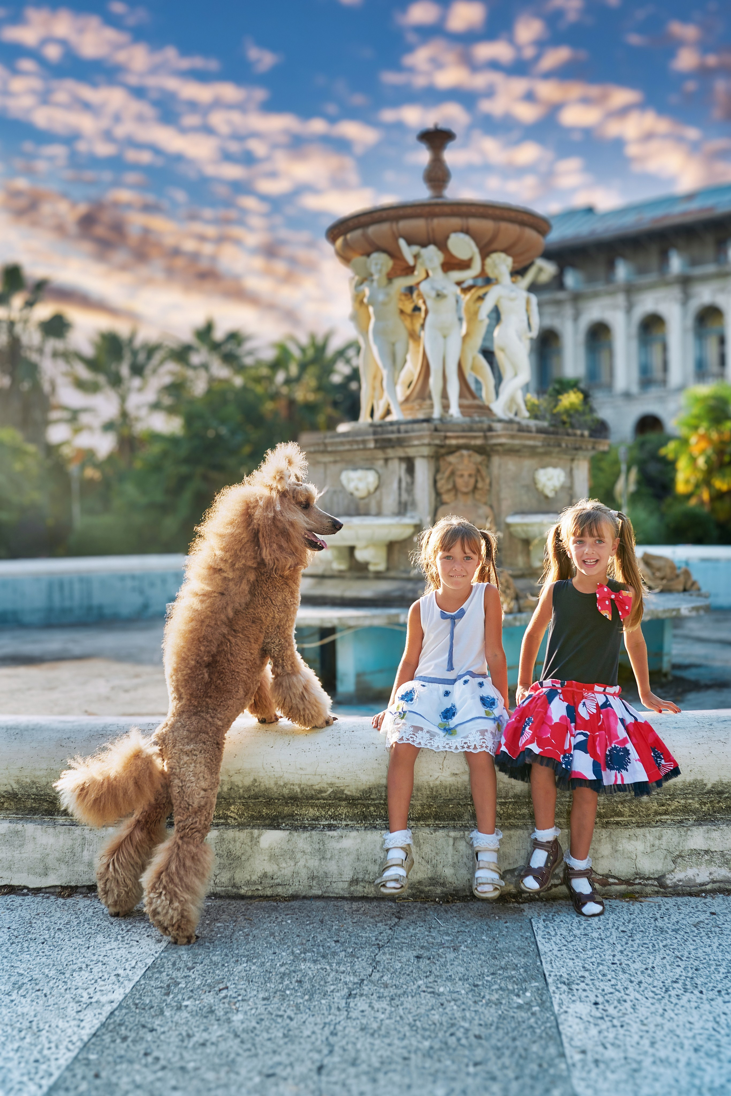 Дети и собака на фоне фонтана.