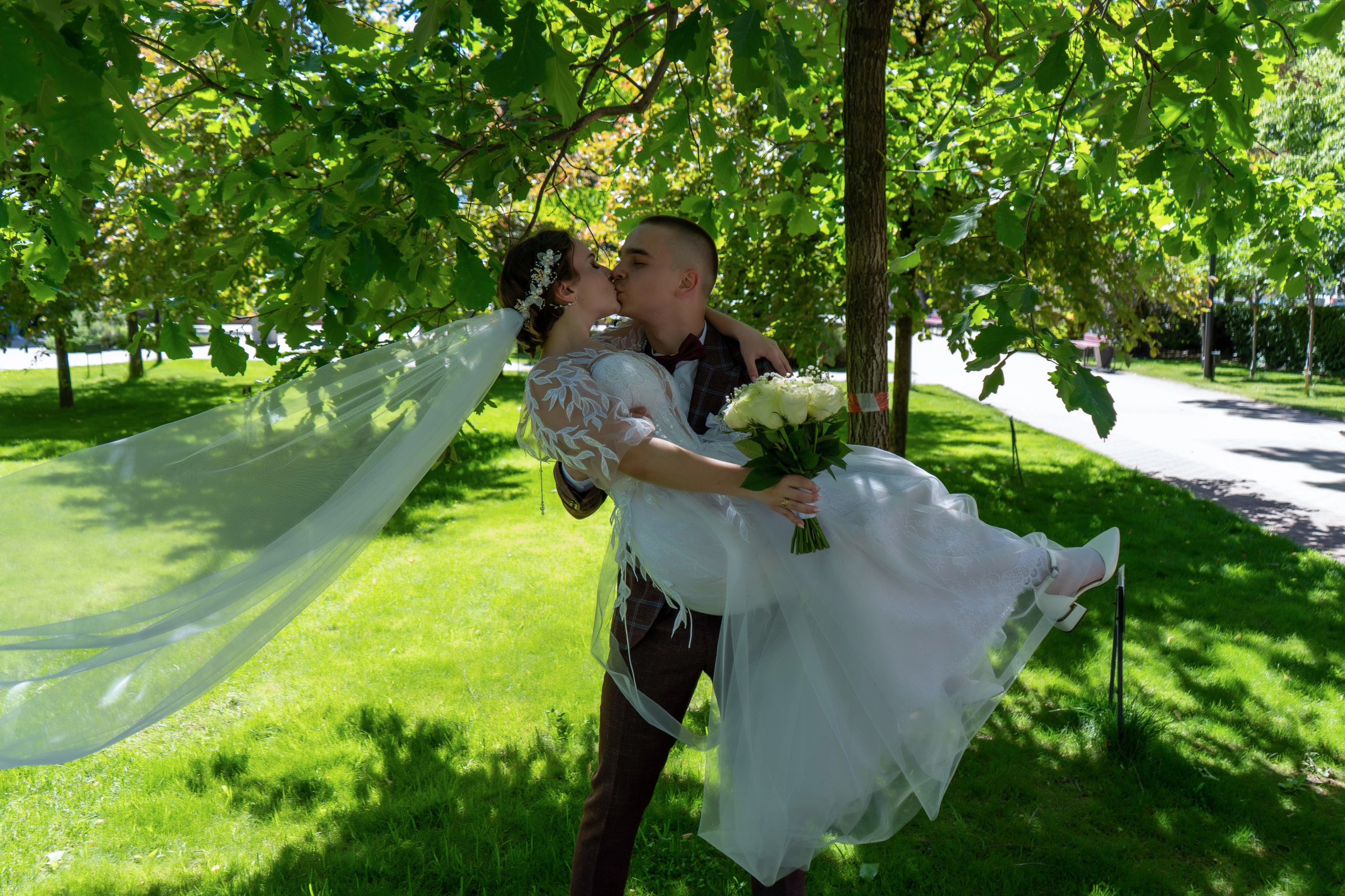 Жених поднял на руки невесту в белом платье с фатой в Воронеже
