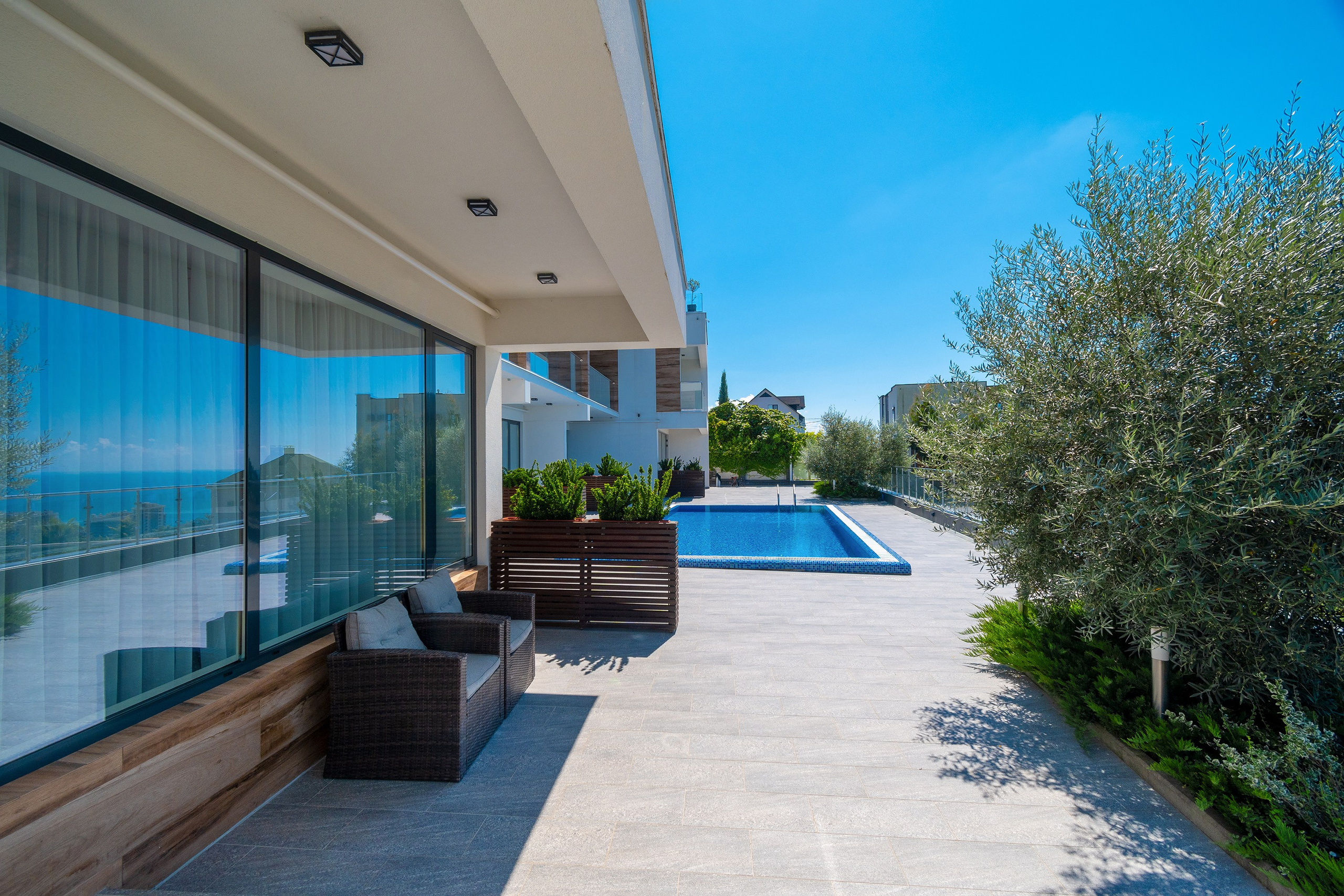 Интерьерная фотосъемка загородного дома с бассейном. Город Сочи. Фасад в современном стиле. Сад и зелень