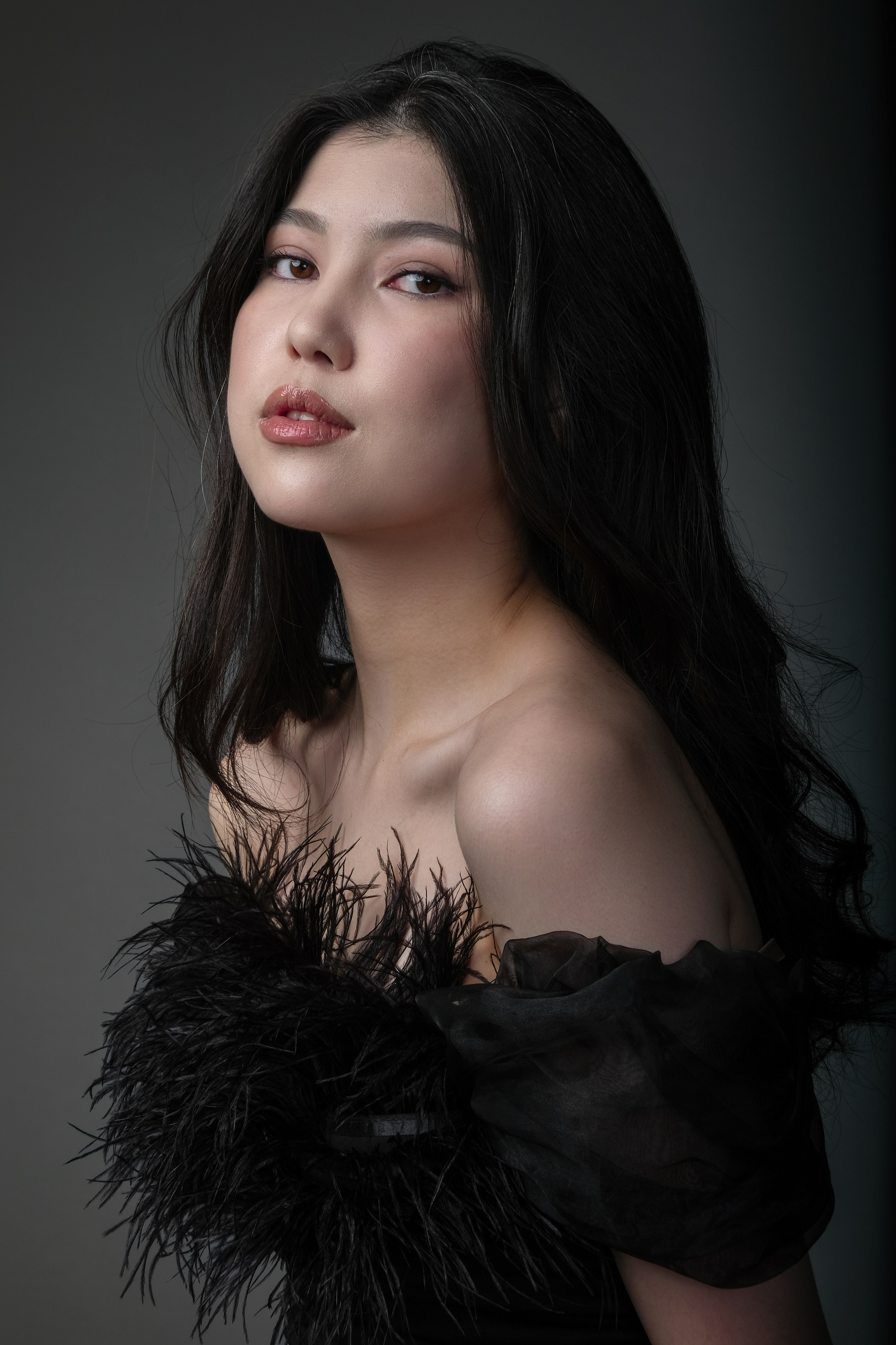 Стильная девушка в черном жакете на фоне студийного фона — портрет с женщиной в  с минималистичным фоном и естественным освещением.