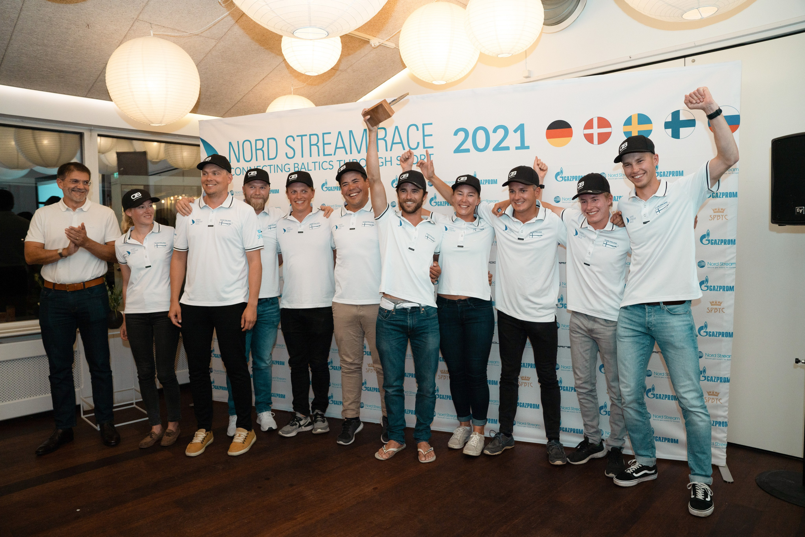 Командное фото яхтсменов из Финляндии на фоне пресс-вола. Международная парусная регата.