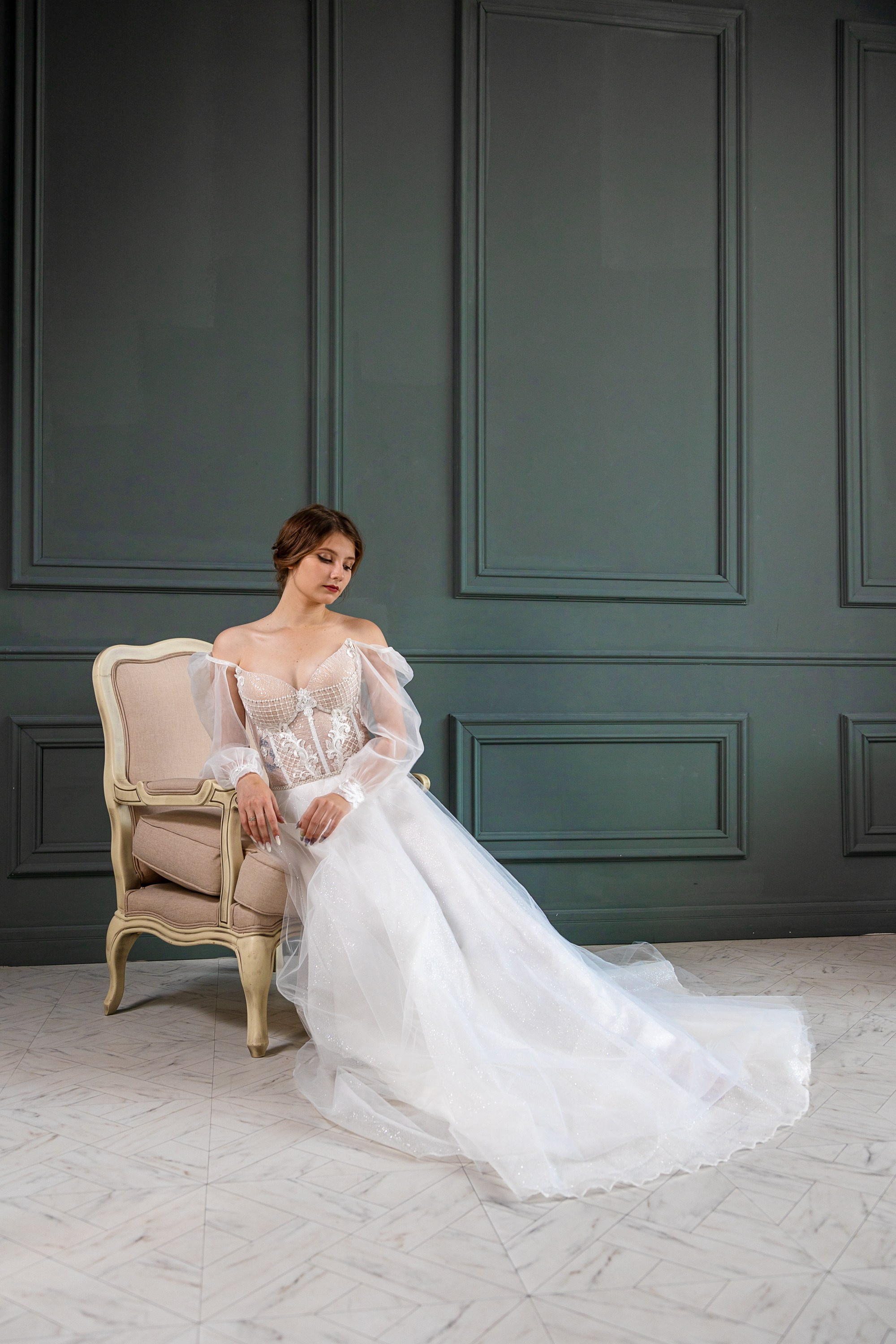 Невеста на тёмной зелёном фоне облокотившись на кресло сидит длинные ноги белое платье красивая девушка Кемерово Кузбасс