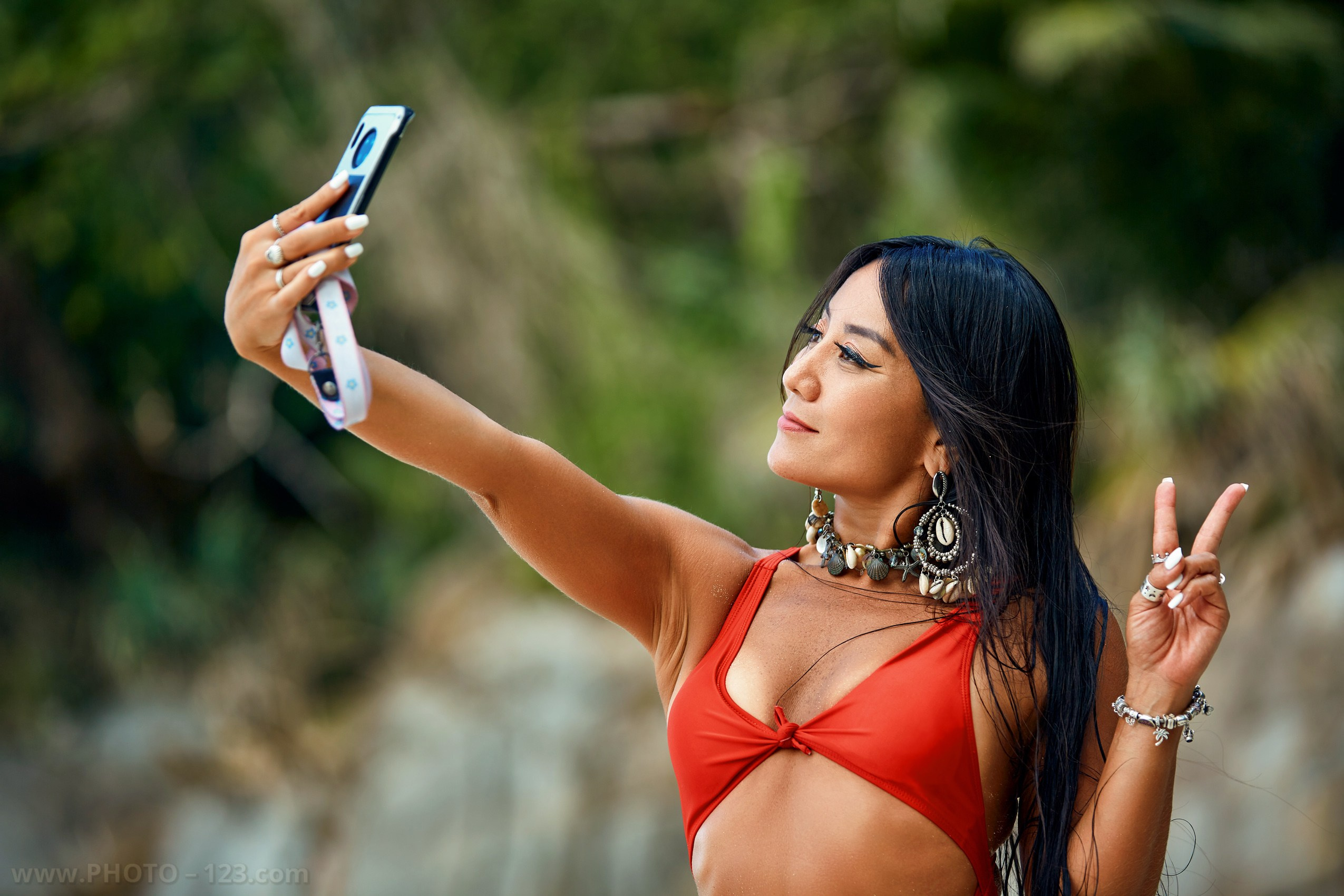 Lifestyle beach portrait of a woman taking a selfie on a tropical coast, natural light photography by a commercial photographer in Vietnam