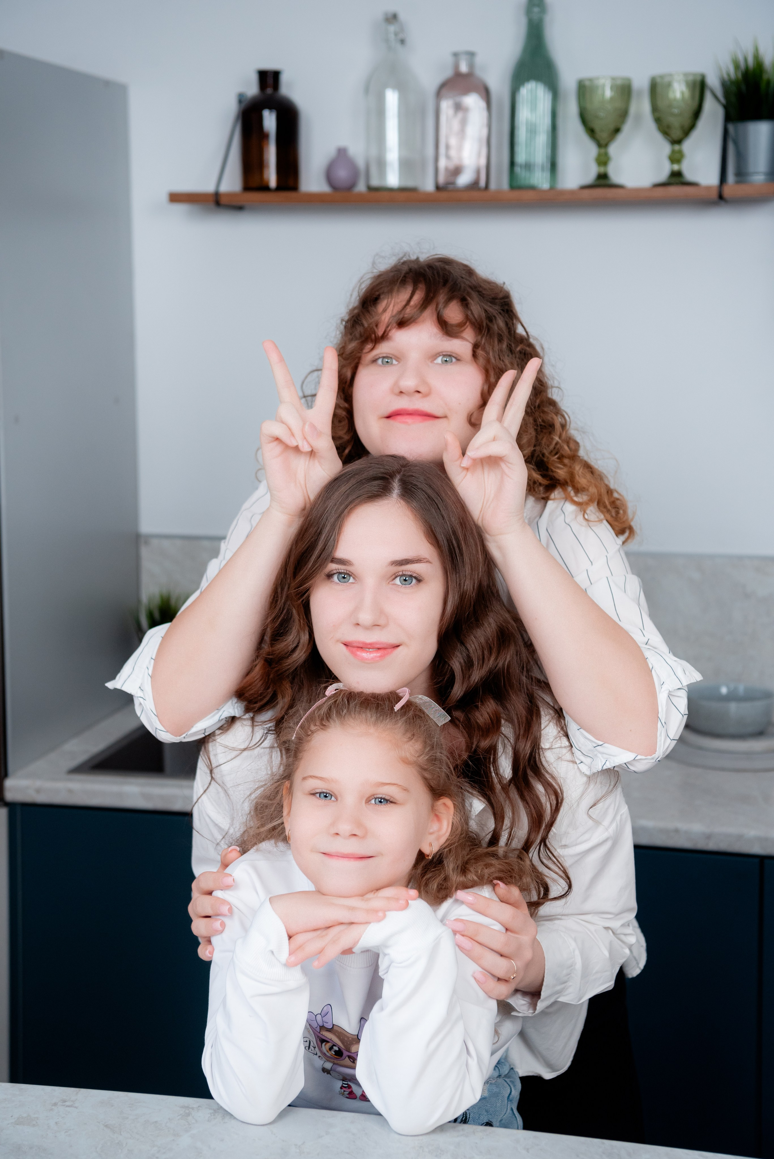 Эмоциональные фото семьи из четырех человек: сестры с разным цветом волос в одинаковых образах.