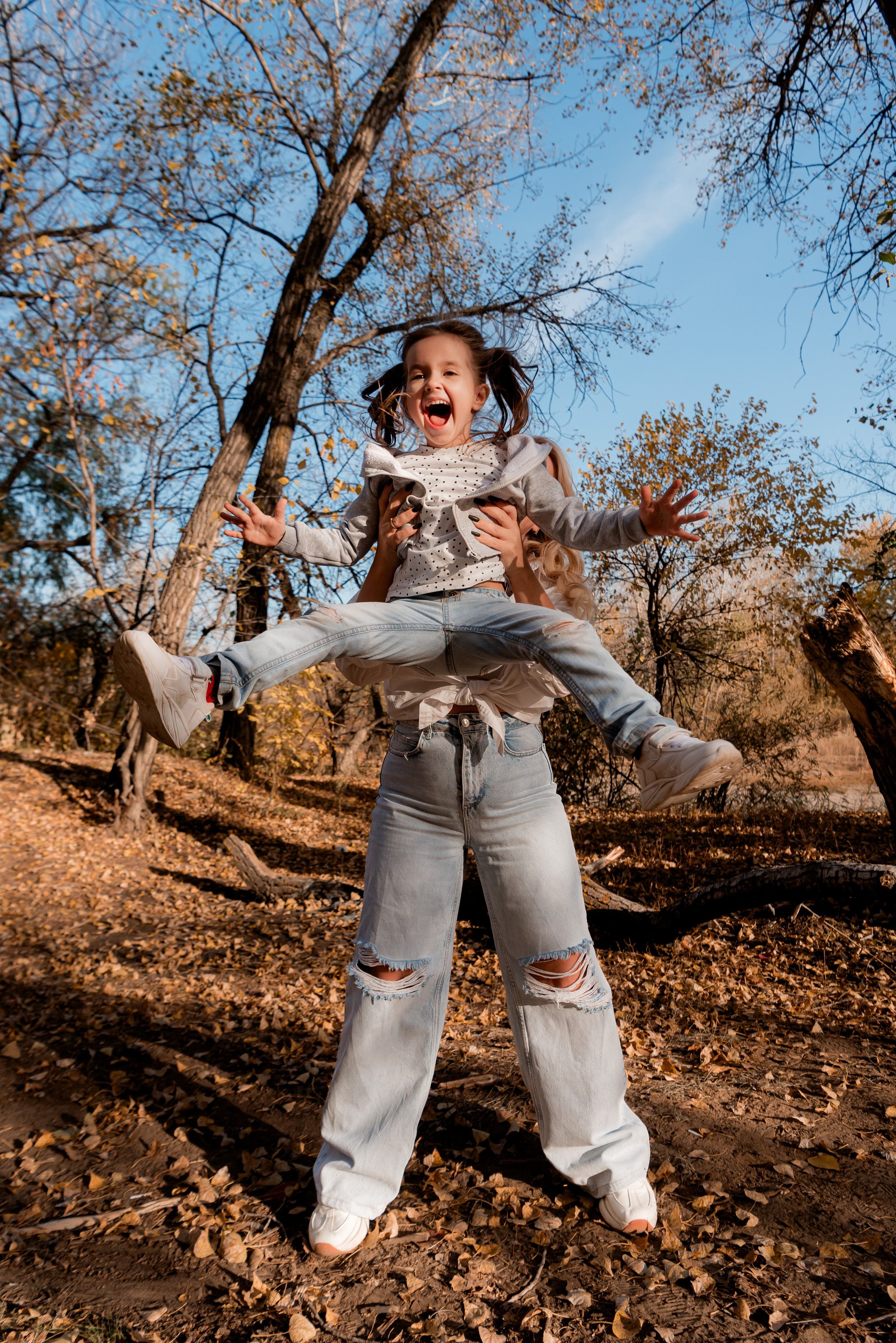 Спонтанный кадр на улице - мама дурачится с дочкой во время фотосессии.