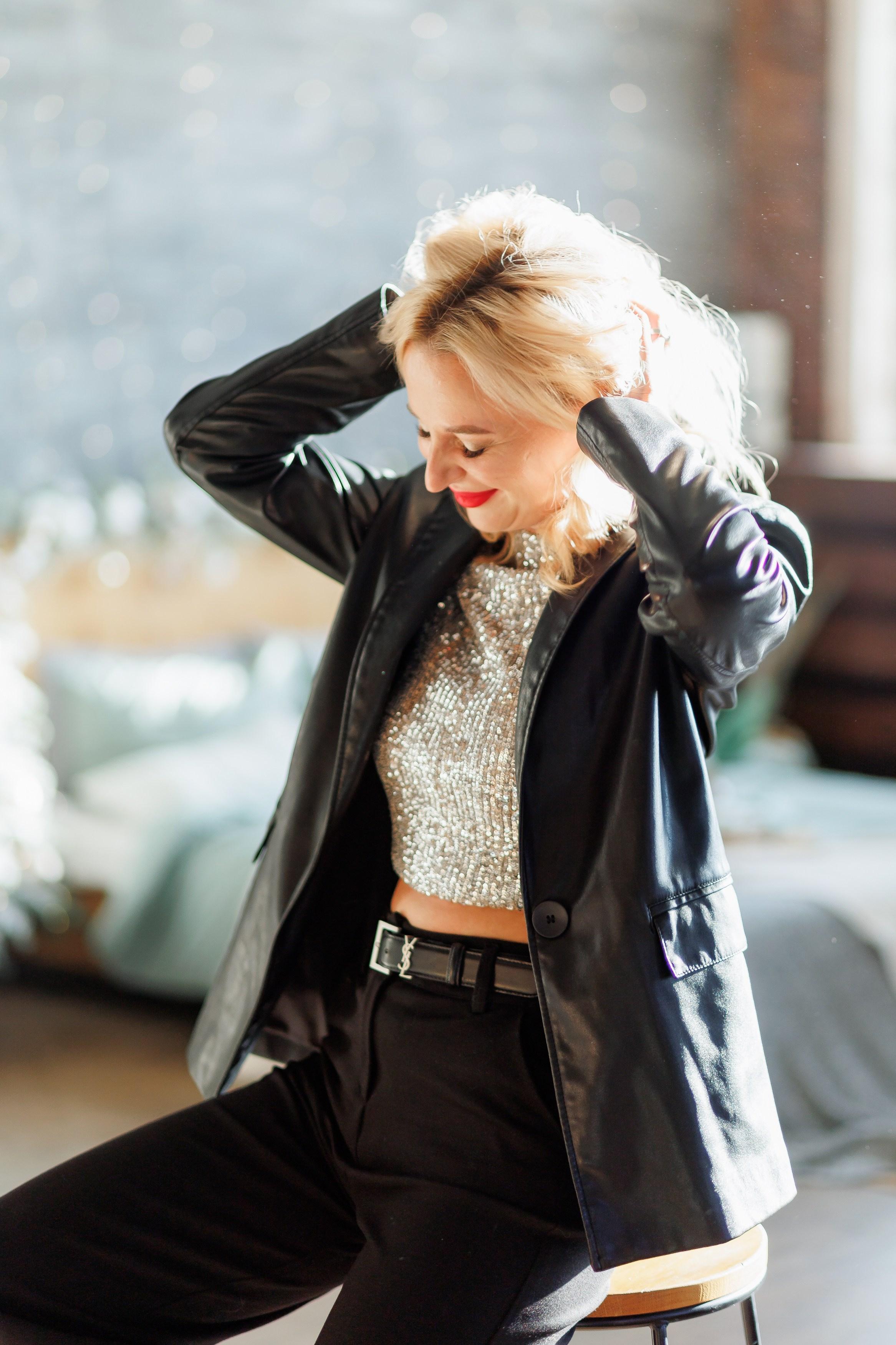 Девушка встряхивает волосы и сидит на стуле