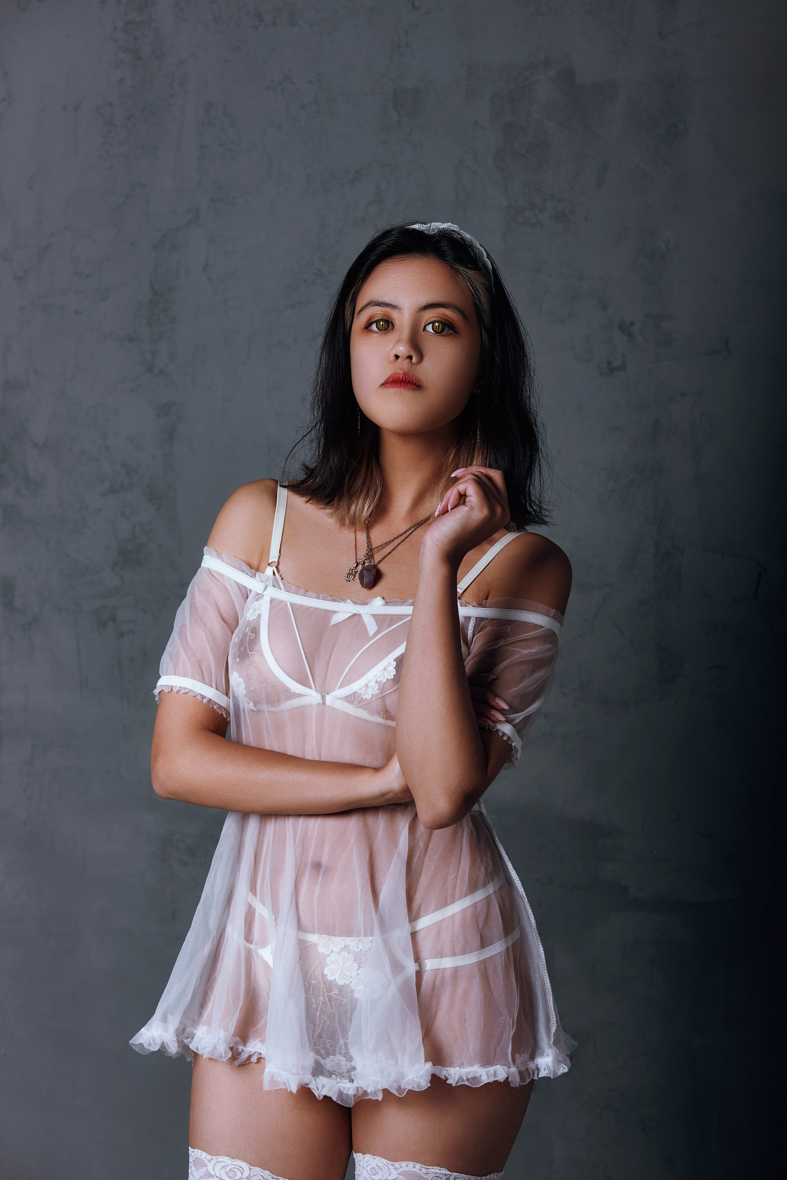 Фотосессия в прозрачном белом белье на сером студийном фоне