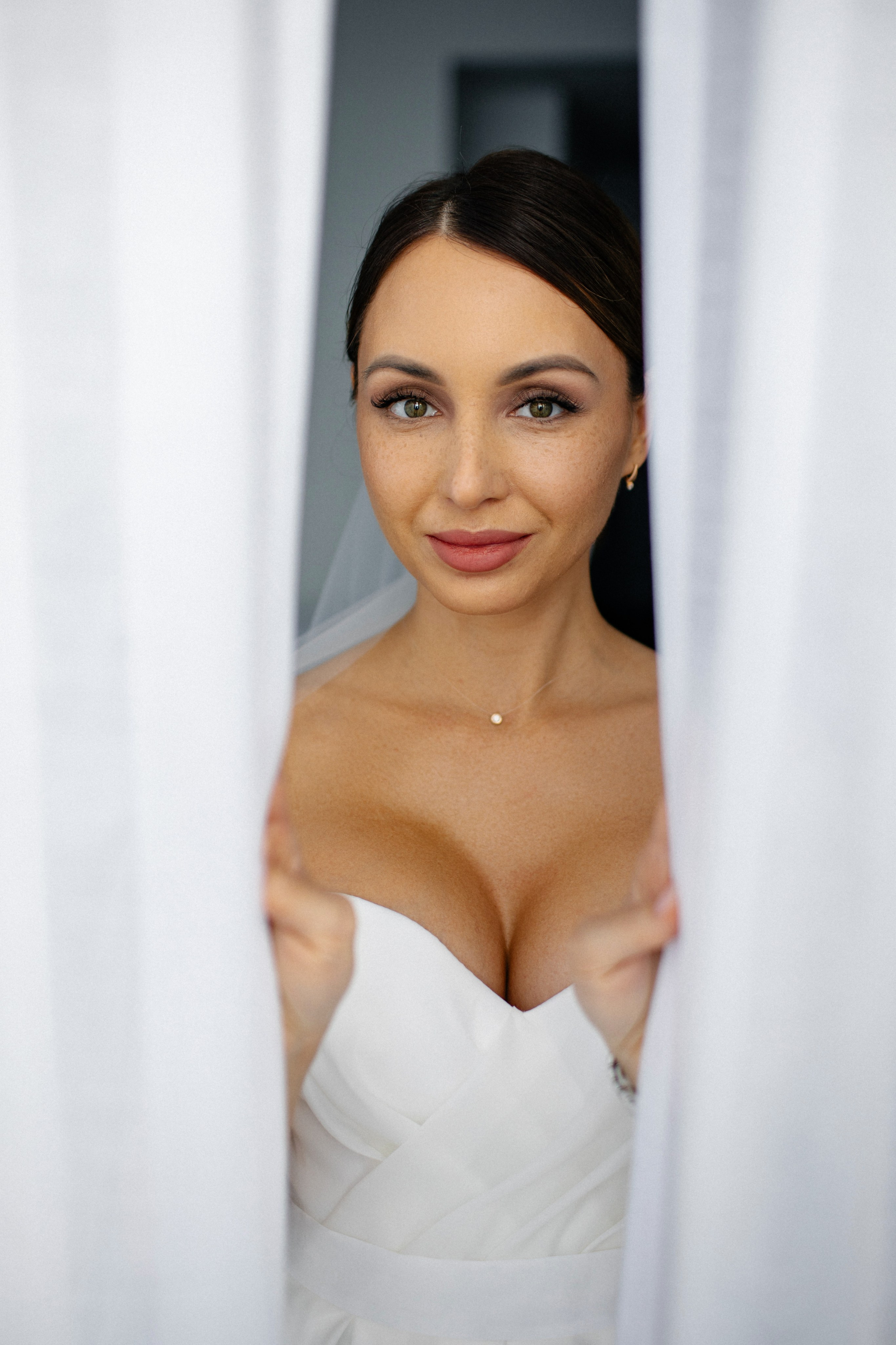 невеста выглядывает из-за штор в гостиничном номере Novotel  в Архангельске фотограф Клещинов Алексей 