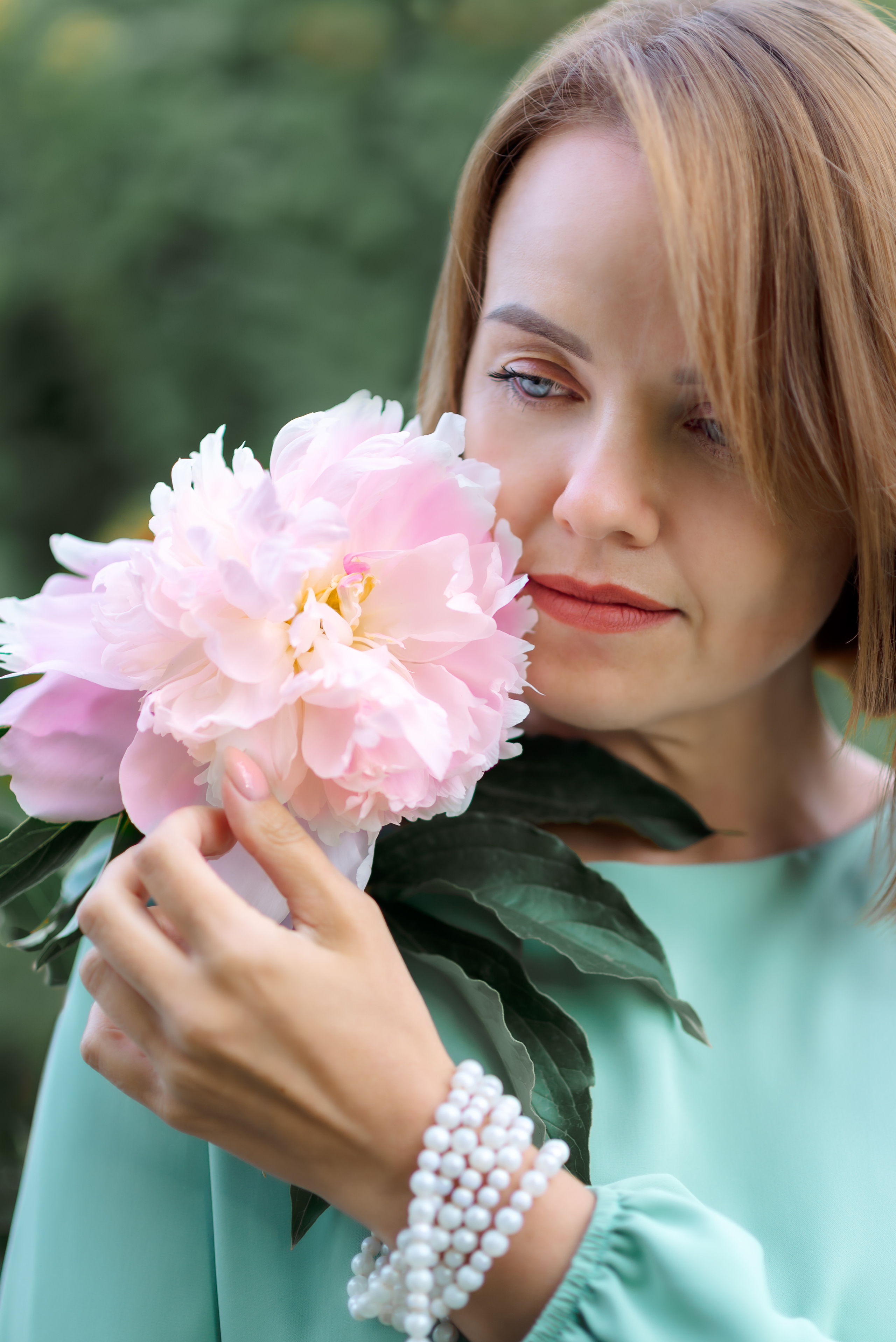 крупный портрет девушки с крупным розовым пионом