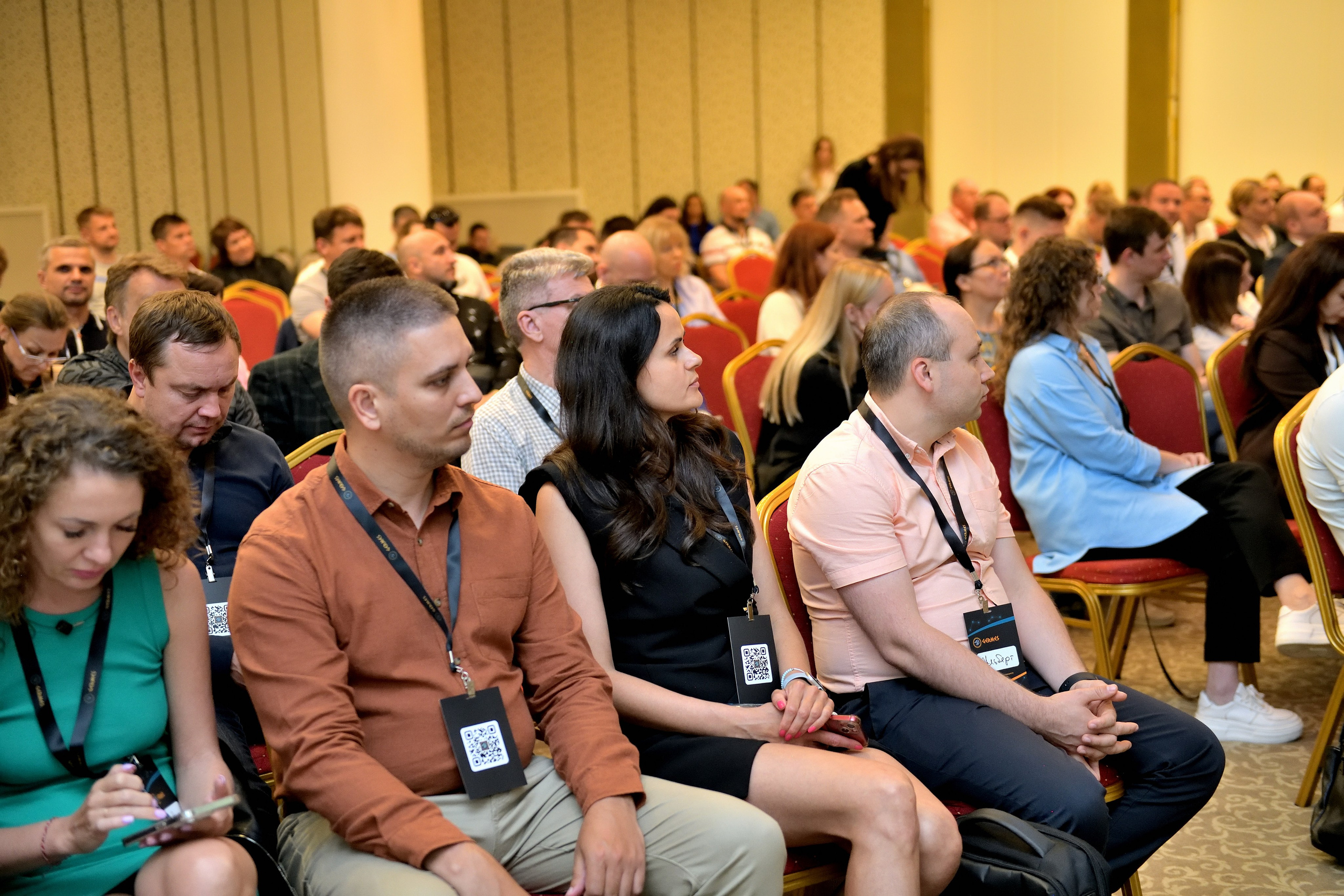 "Участники конференции внимательно слушают спикера".
