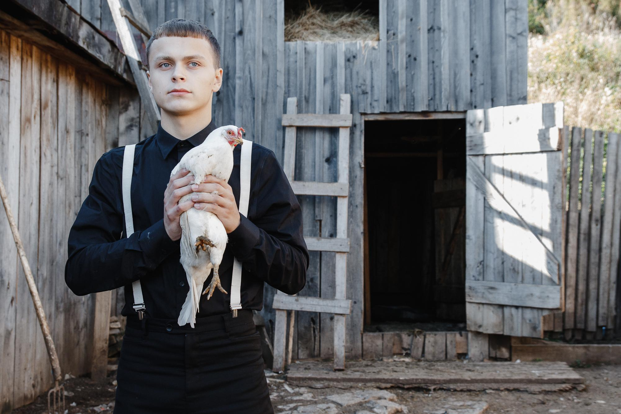 мужчина с курицей в деревне