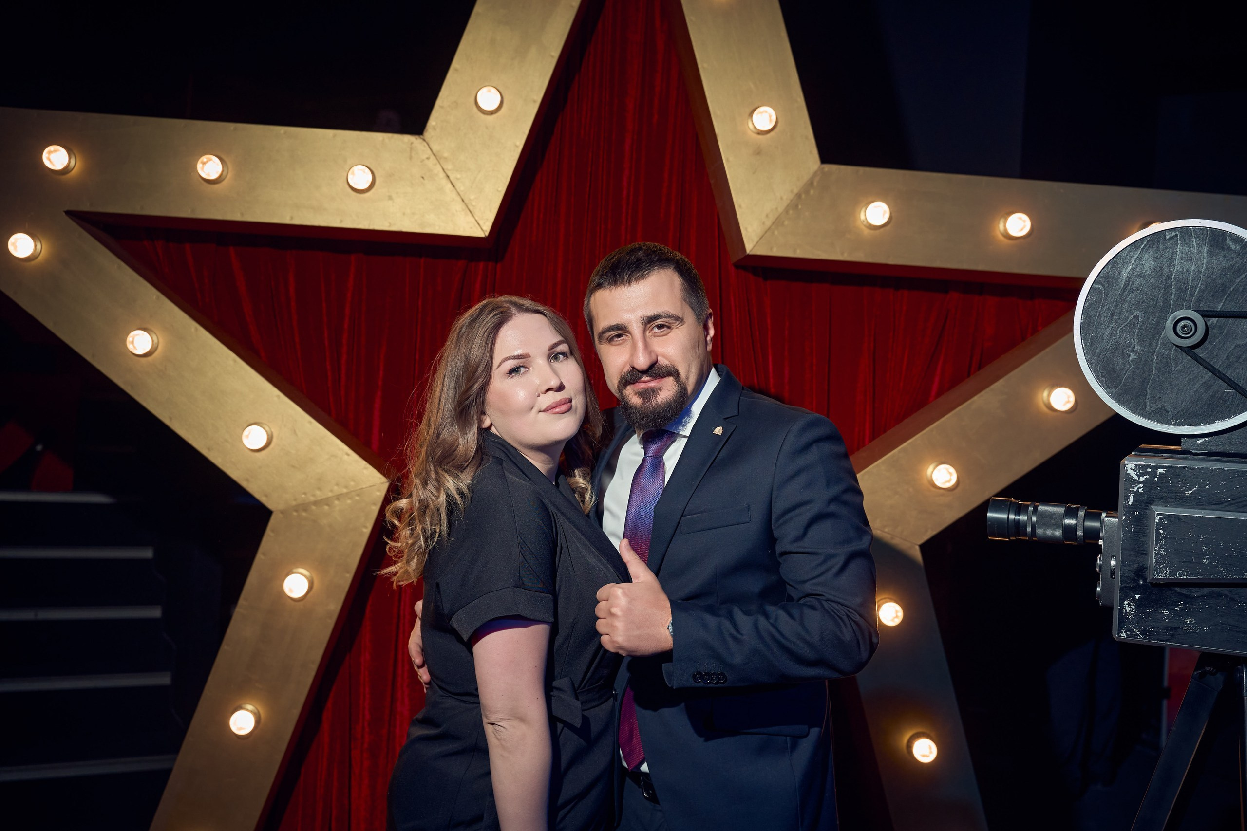 двое людей на фотозоне позируют для репортажного фотографа