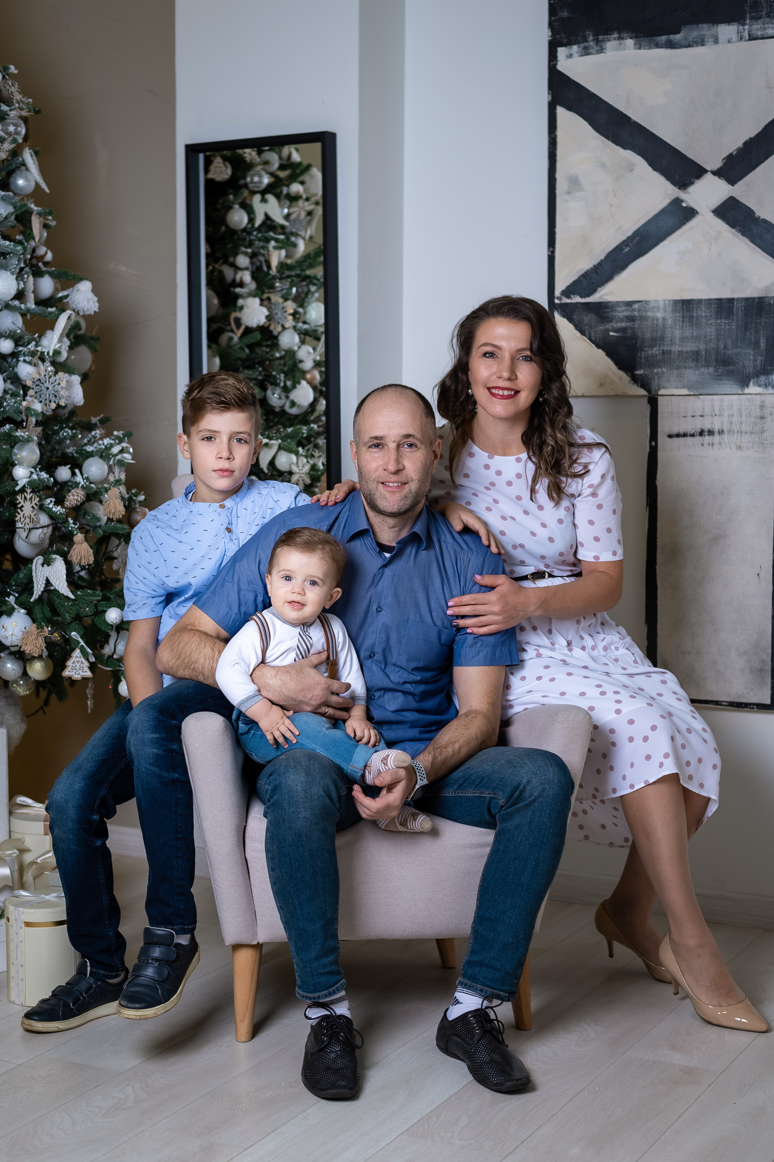 фото 4 человек на фоне елки и зеркала на заднем плане.