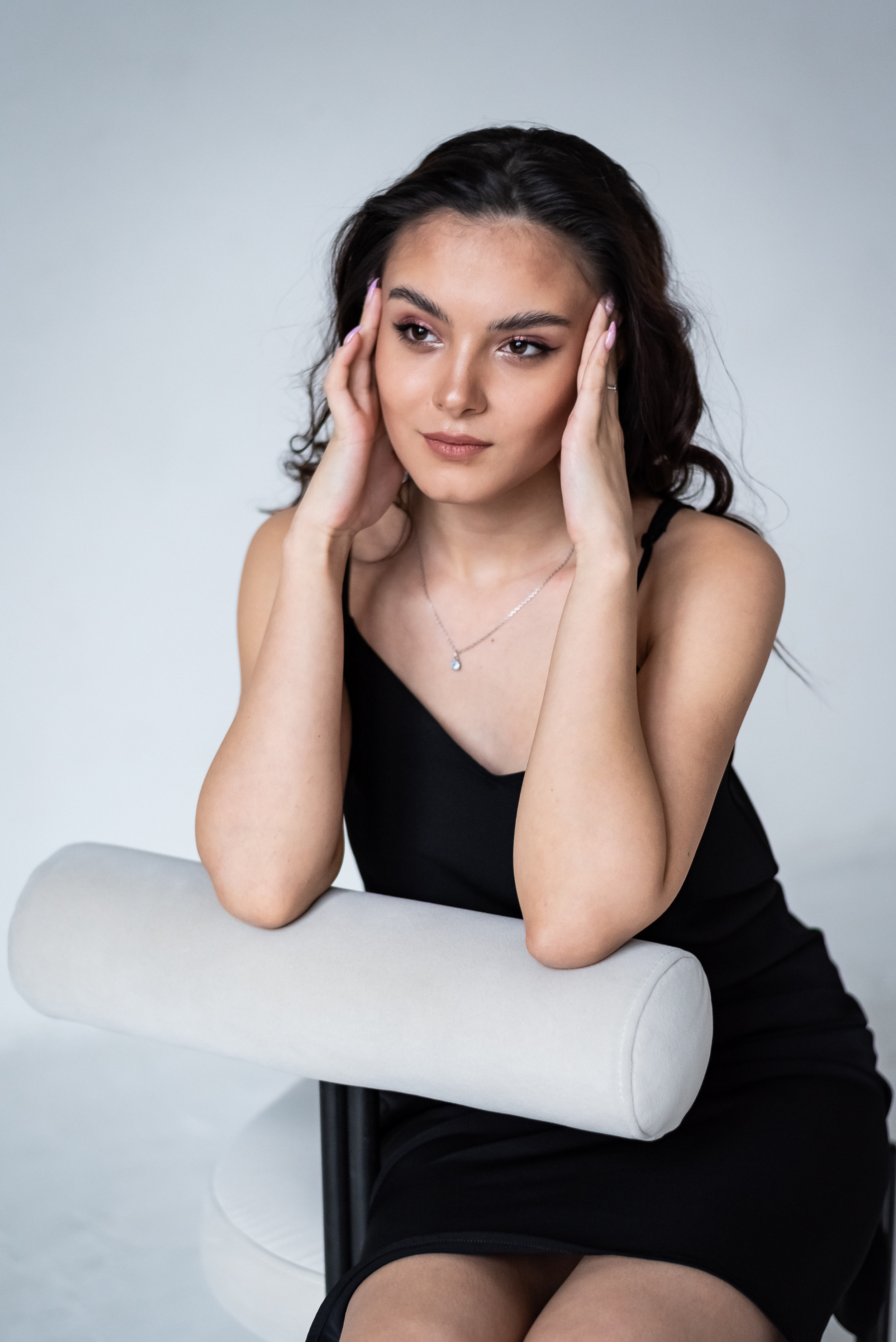 средний план девушки в темном платье, которая сидит на стуле
