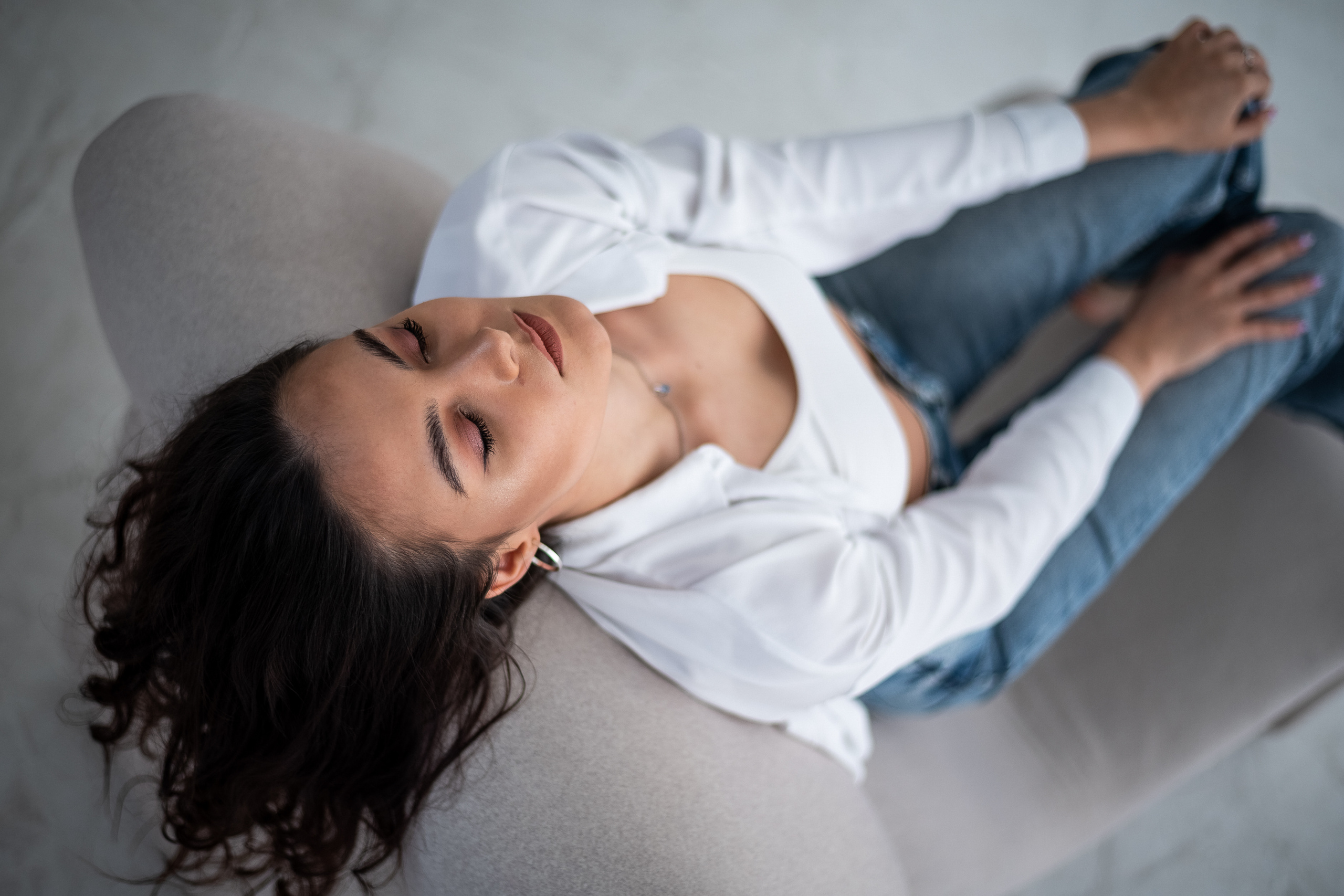 ракурс сверху девушки которая откинулась на спинку стула с закрытыми глазами