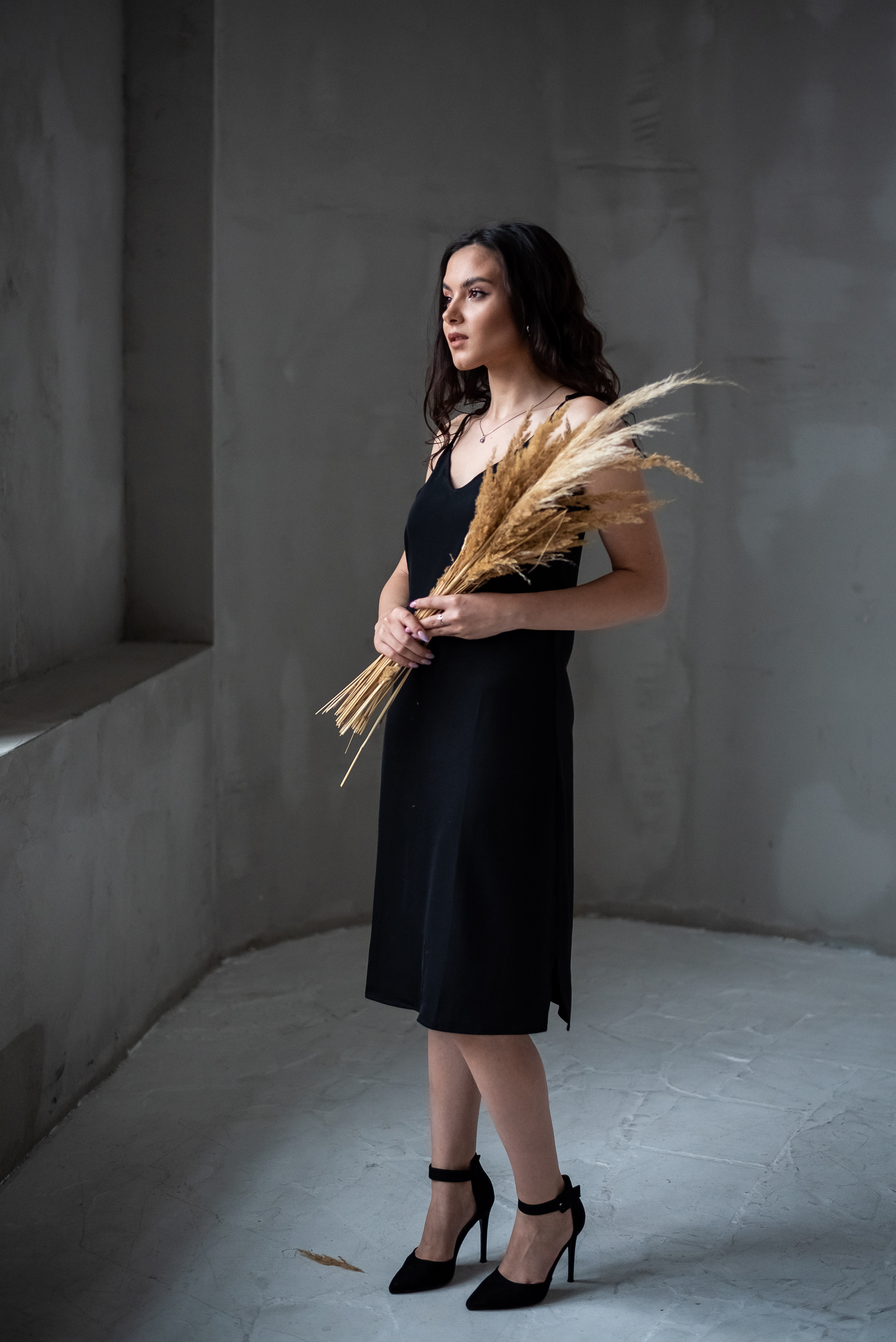 девушка стоя у окна с сухоцветами в руках в полный рост 