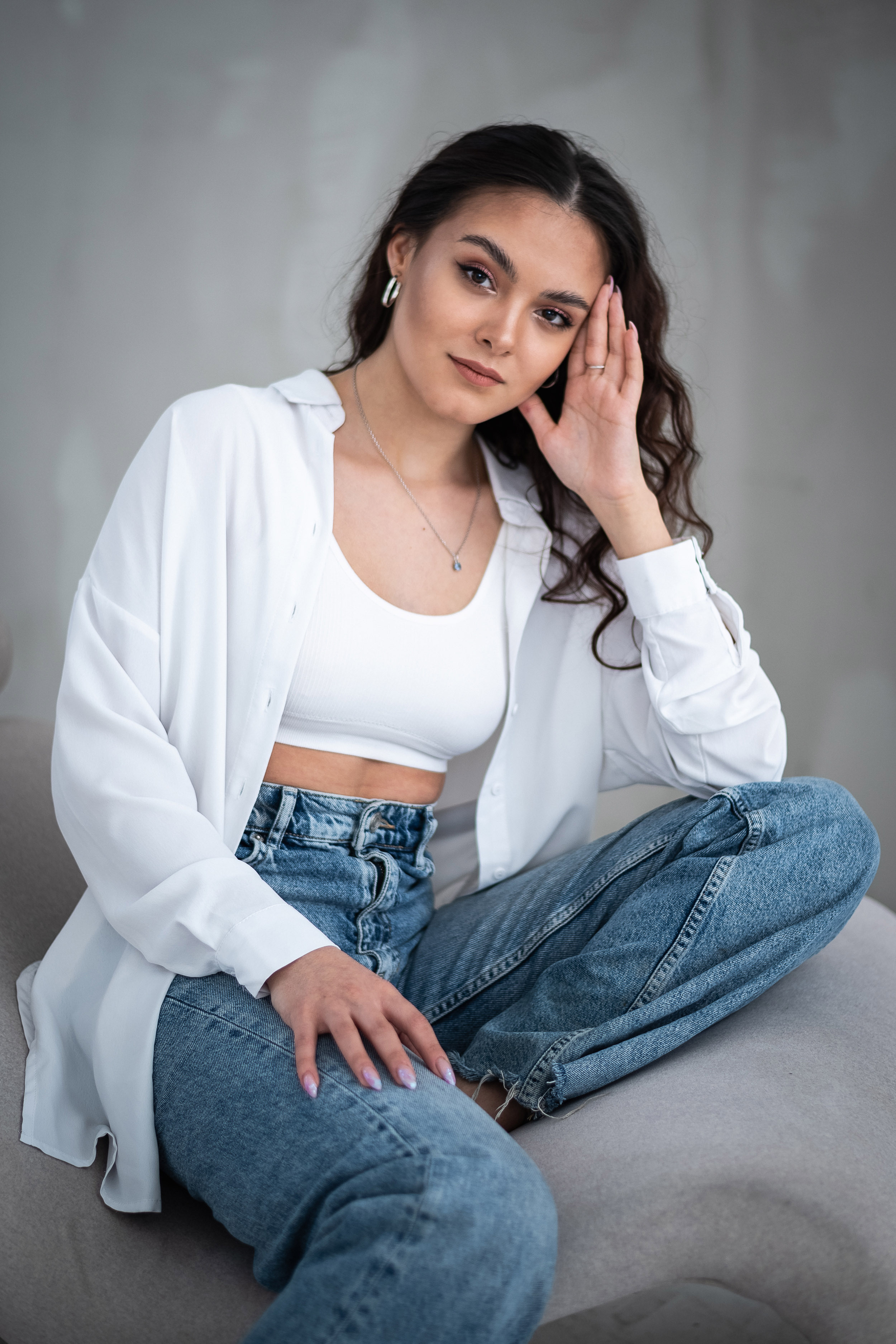 девушка с вьющимися русыми волосами сидит опираясь на руку 