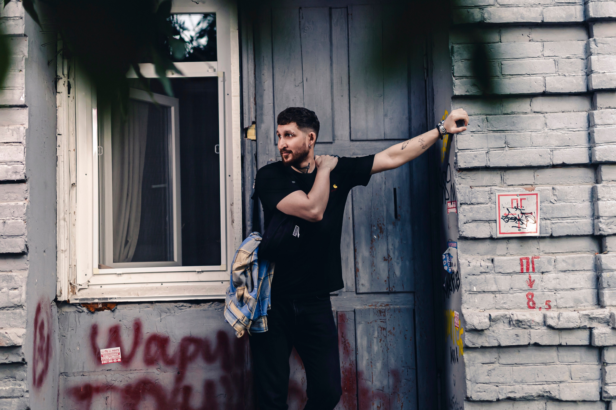 мужчина опирается рукой на стену 