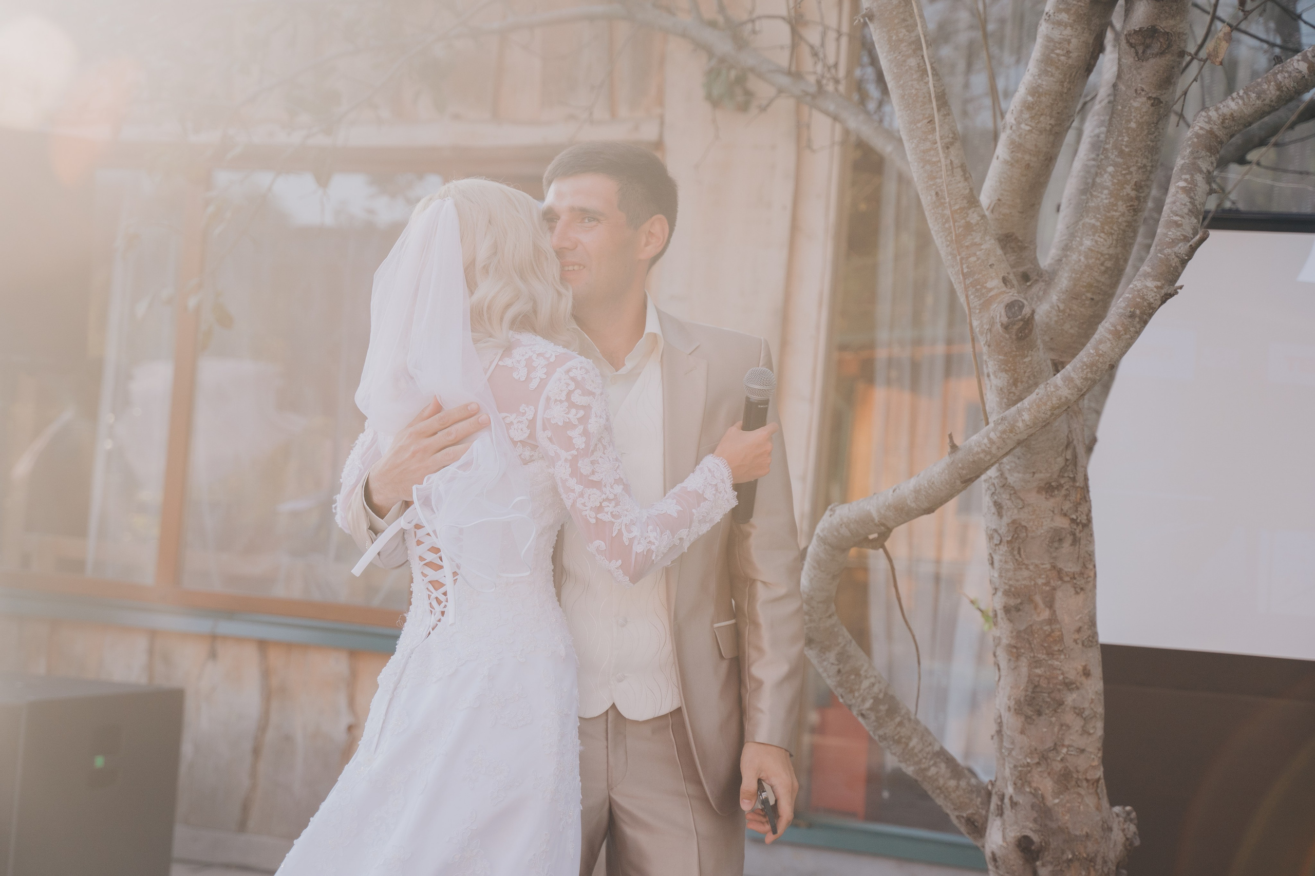 Снимок молодожен обнимающих на закате