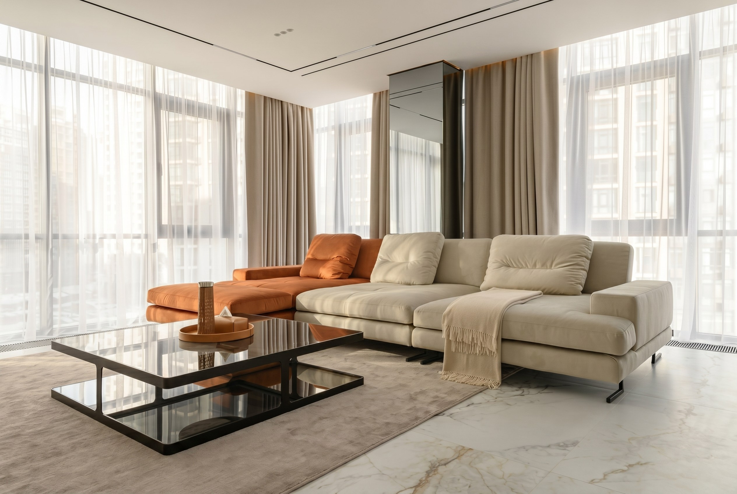 Зона отдыха в интерьере квартиры 116 м² от Валерии Котович (Краснодар): мягкий диван с терракотовым акцентом, зеркальные вставки в интерьере и текстильное оформление панорамных окон.