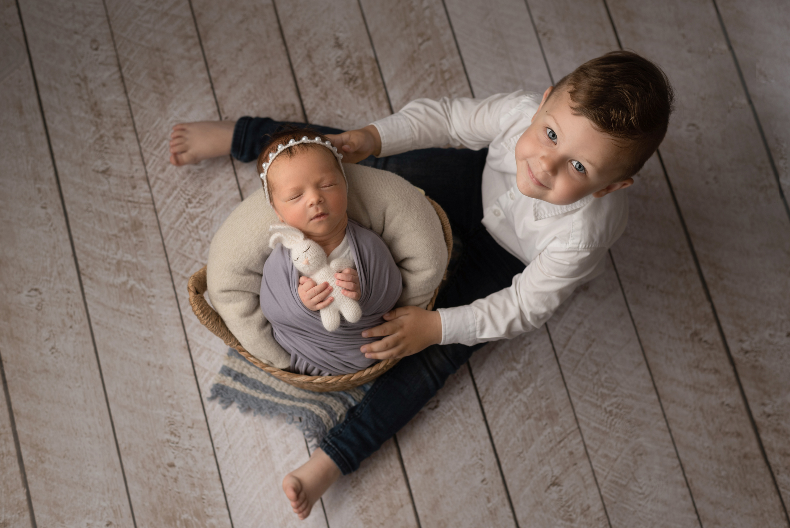 Brother holding a basket with sister