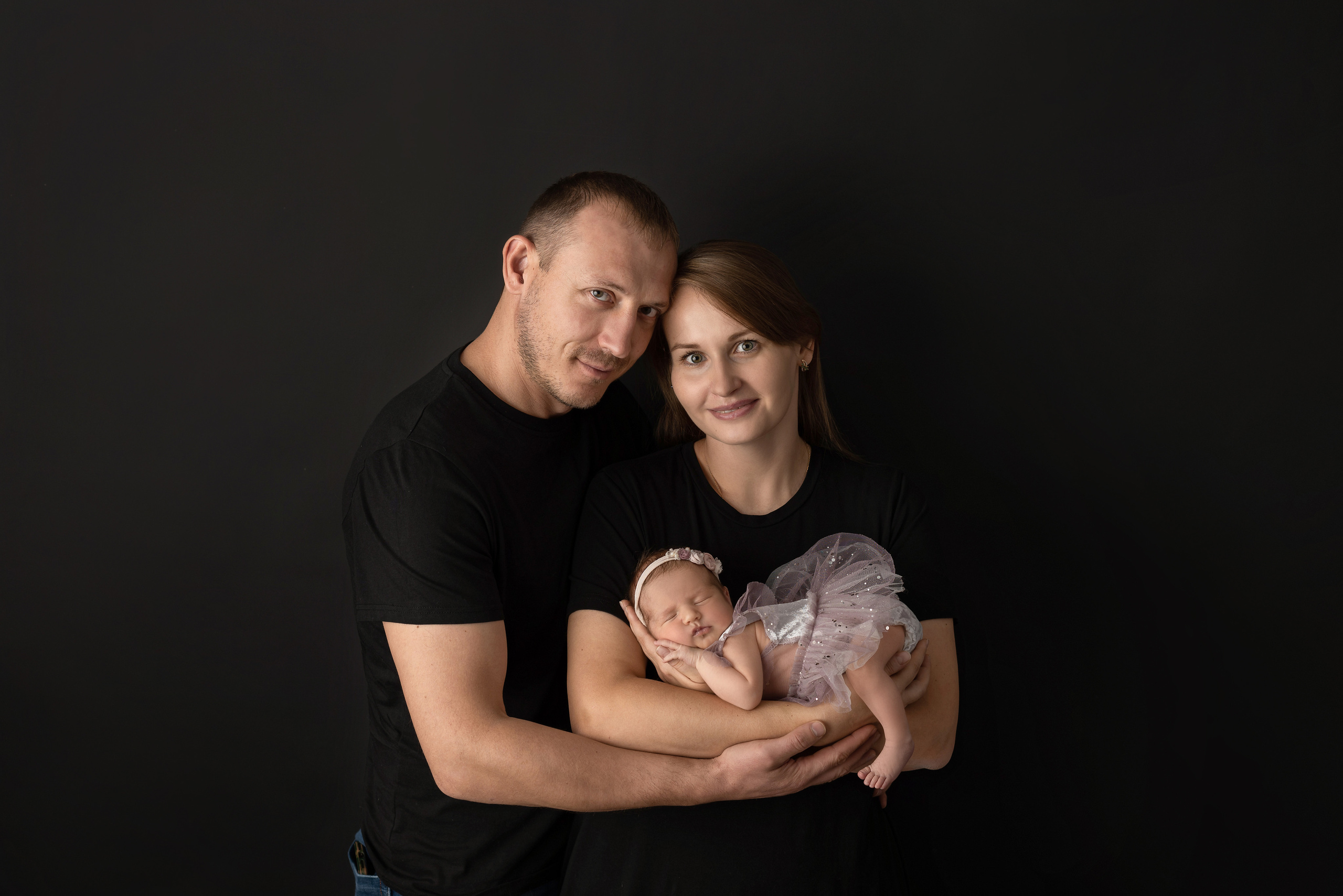 Dad gently holds mom and daughter by the hand