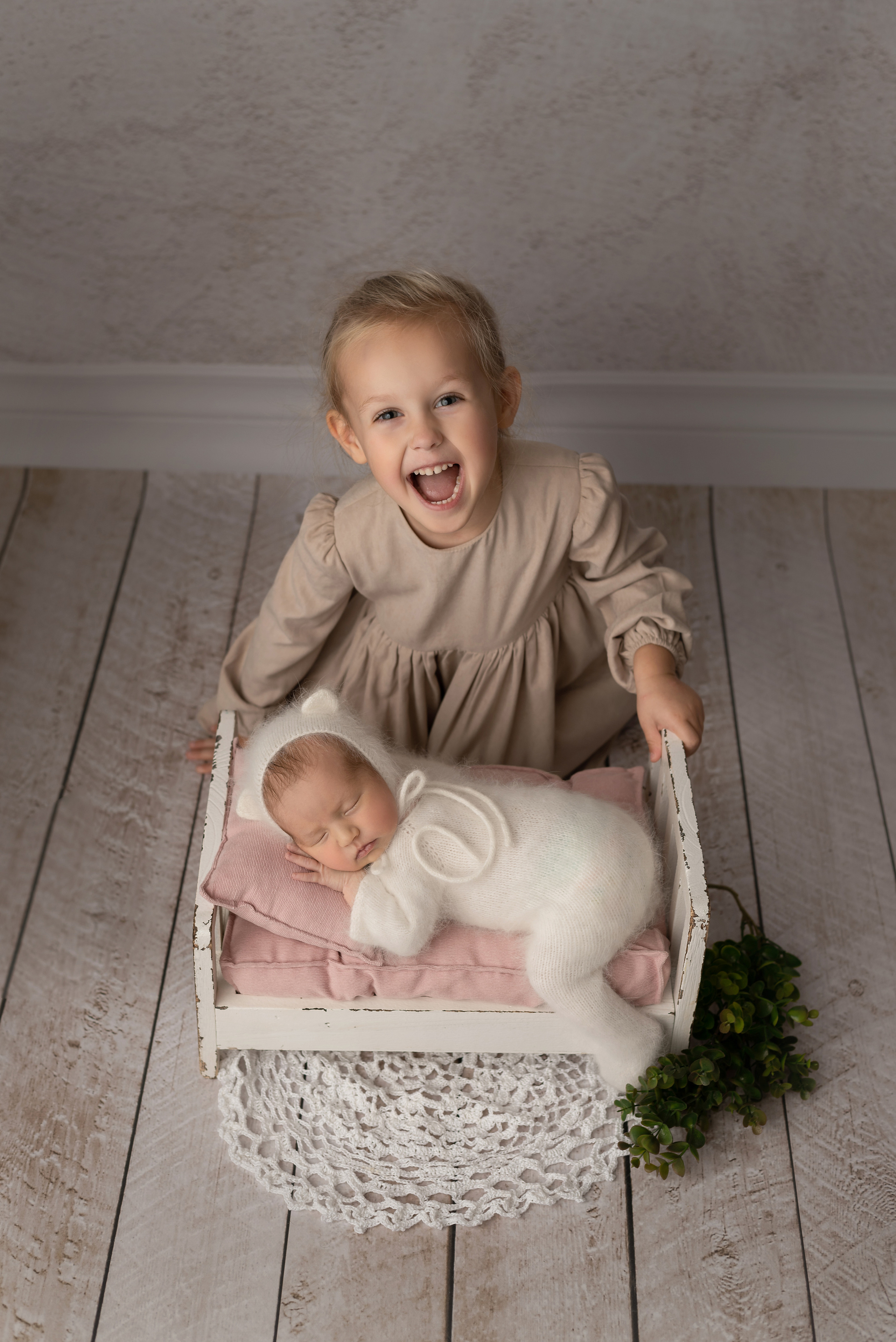 Sister with newborn sister smiling