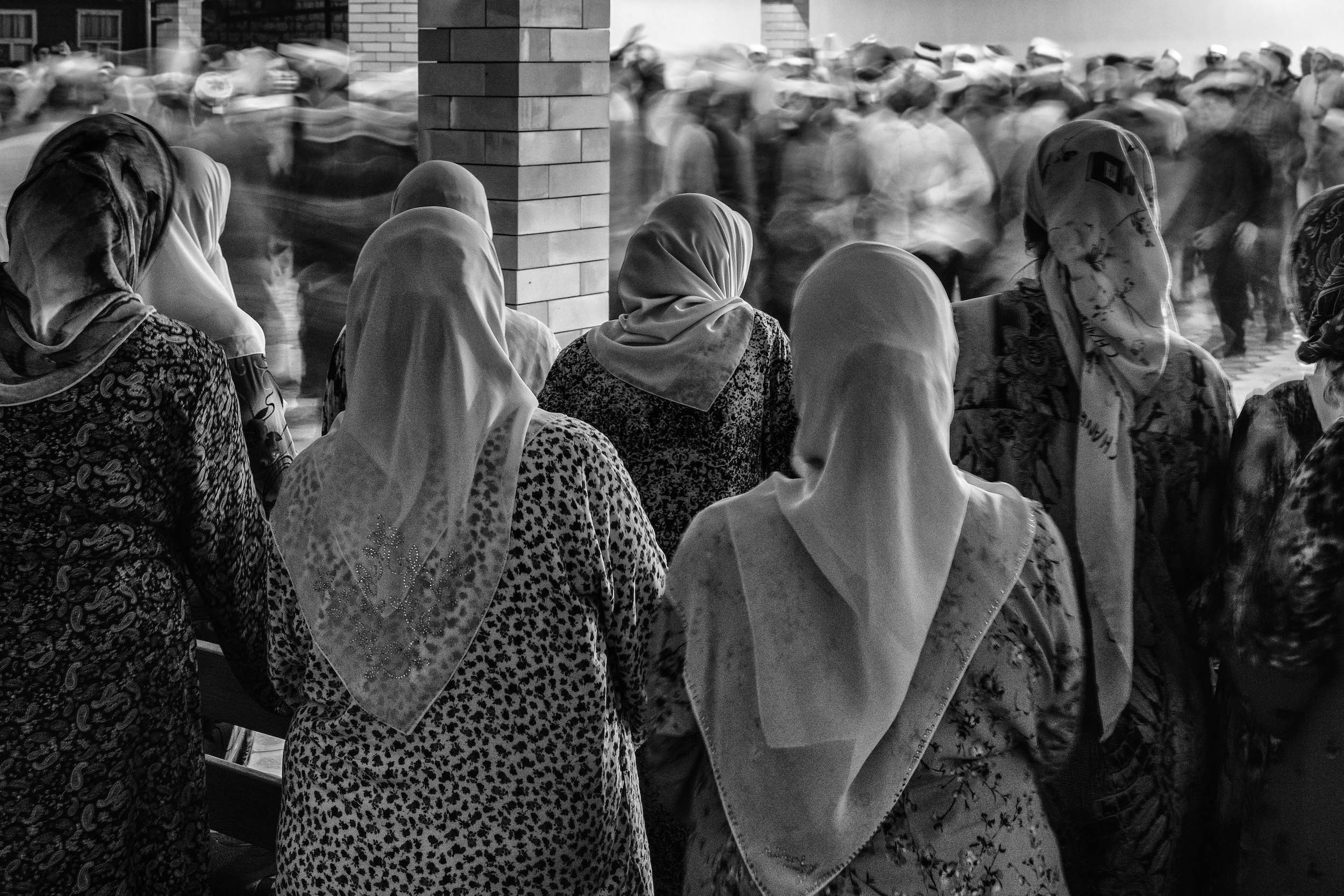 Женщины молча наблюдают за поминанием Бога.