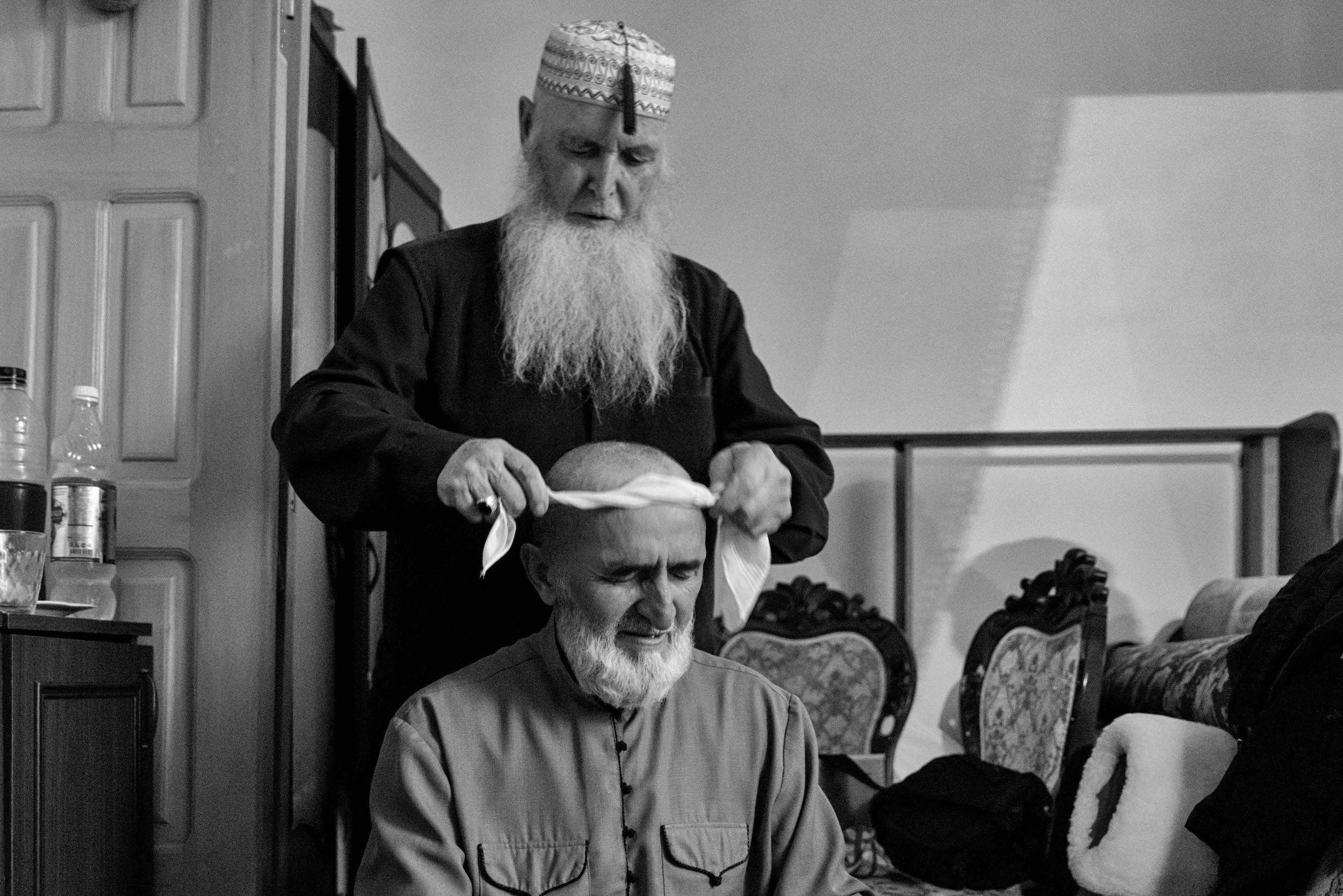 Целитель помогает усталому участнику обряда прийти в себя.