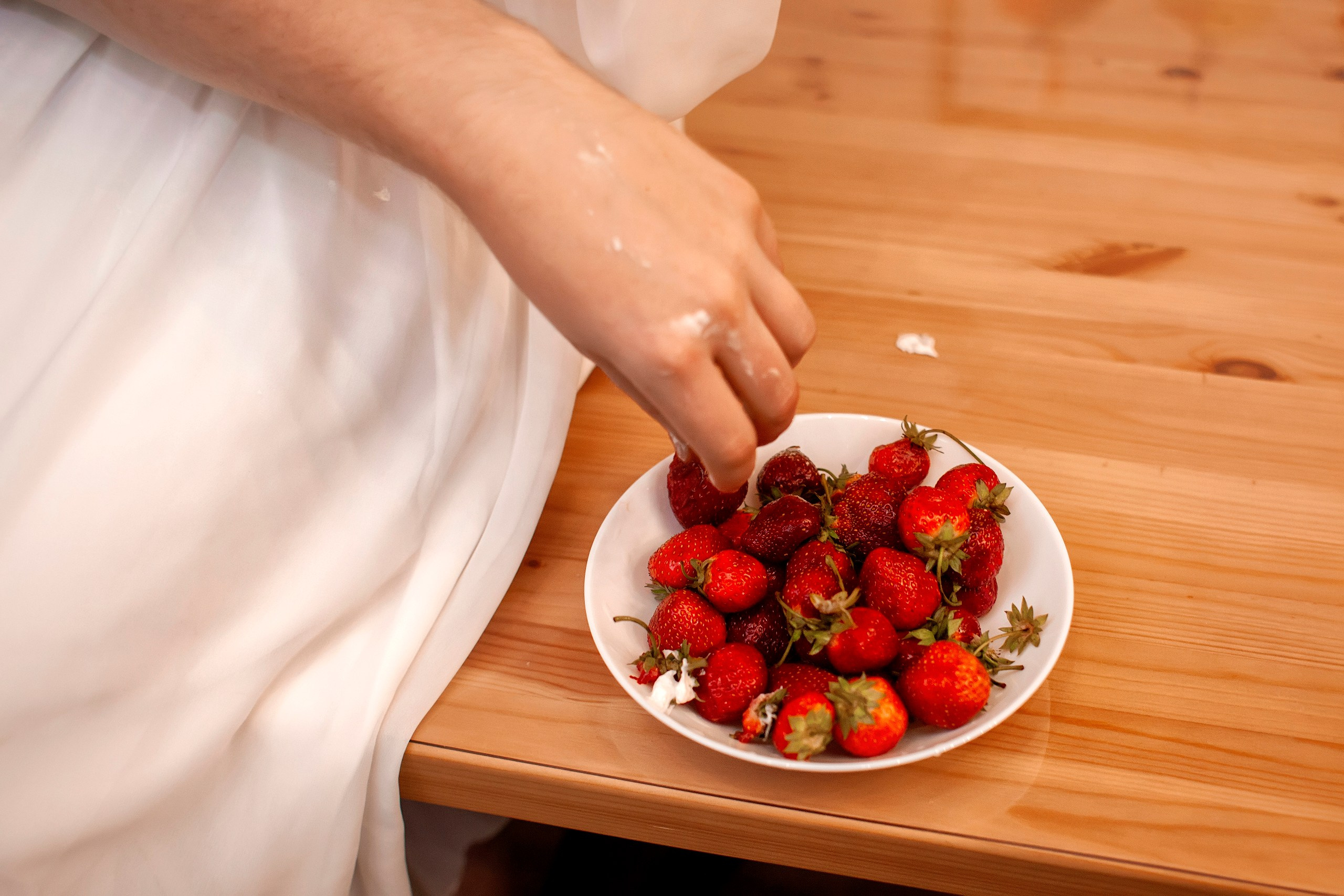 Тарелка с клубникой на столе - съёмка деталей 