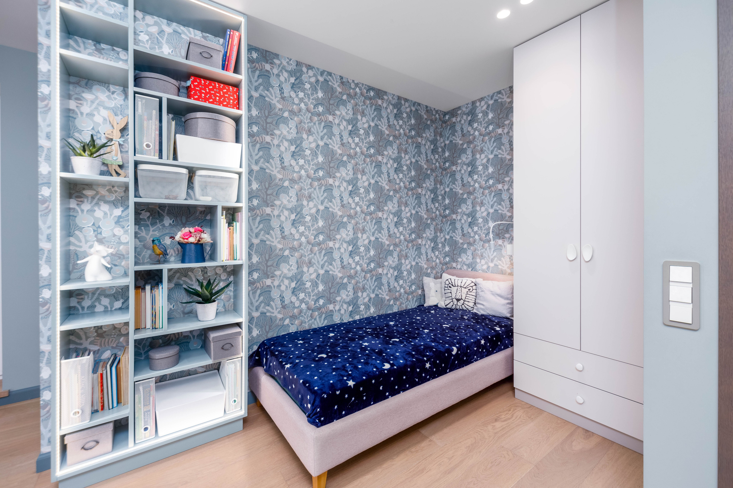 Кровать и зона хранения в детской в четырехкомнатной квартире в Минске