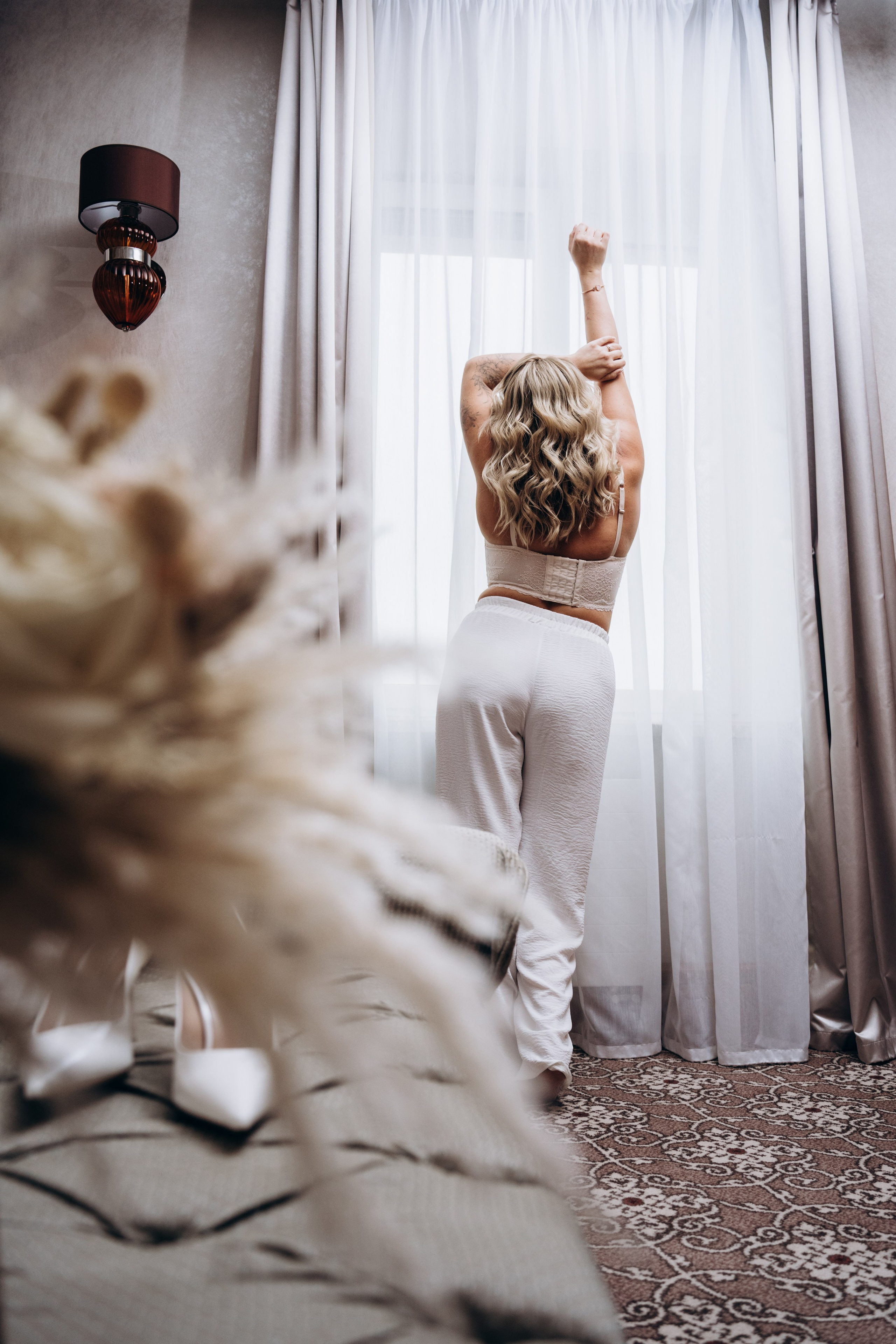 Невеста в свадебном платье смотрится в зеркало — трогательные моменты сборов перед церемонией, запечатленные фотографом.