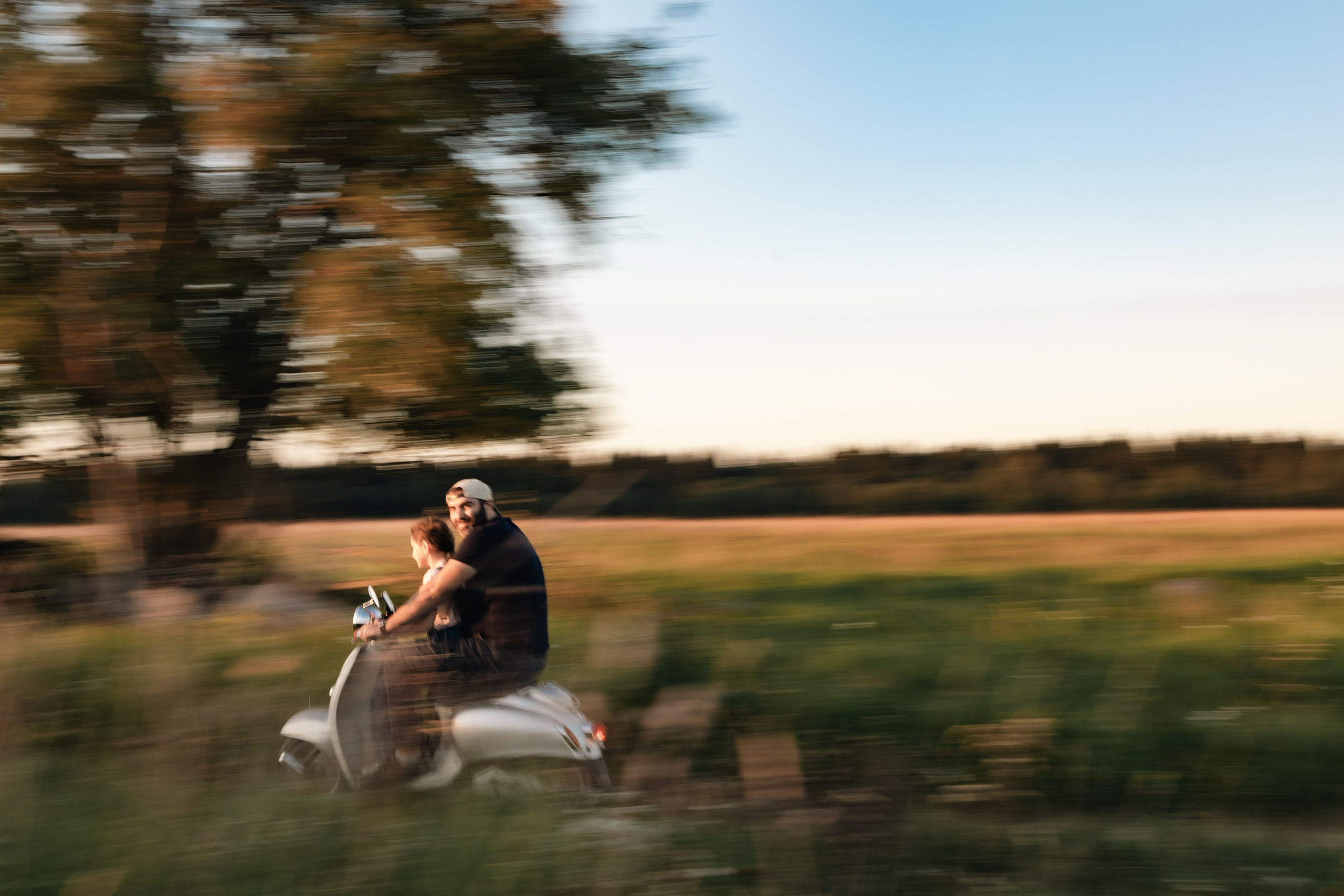 папа с дочкой едут на мопеде кадр в движении с размытием