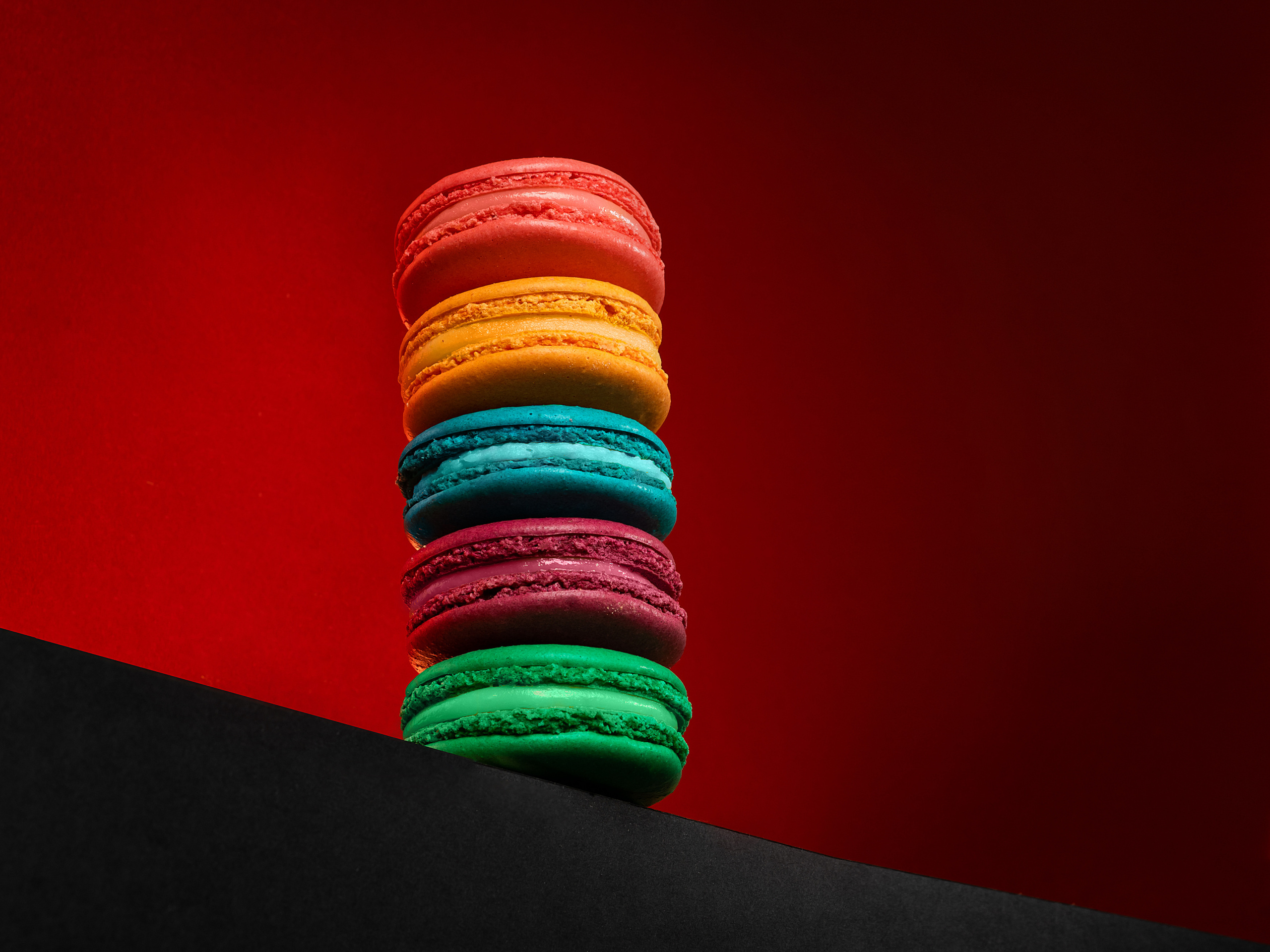 Hero view десерта из цветных макарун  на ярко-красном фоне