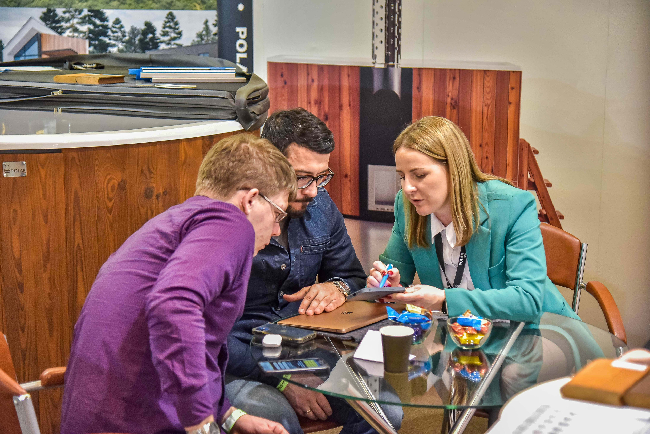 Репортажная съемка с выставки в Москве: снимок передаёт общение между представителем компании и посетителями выставки.