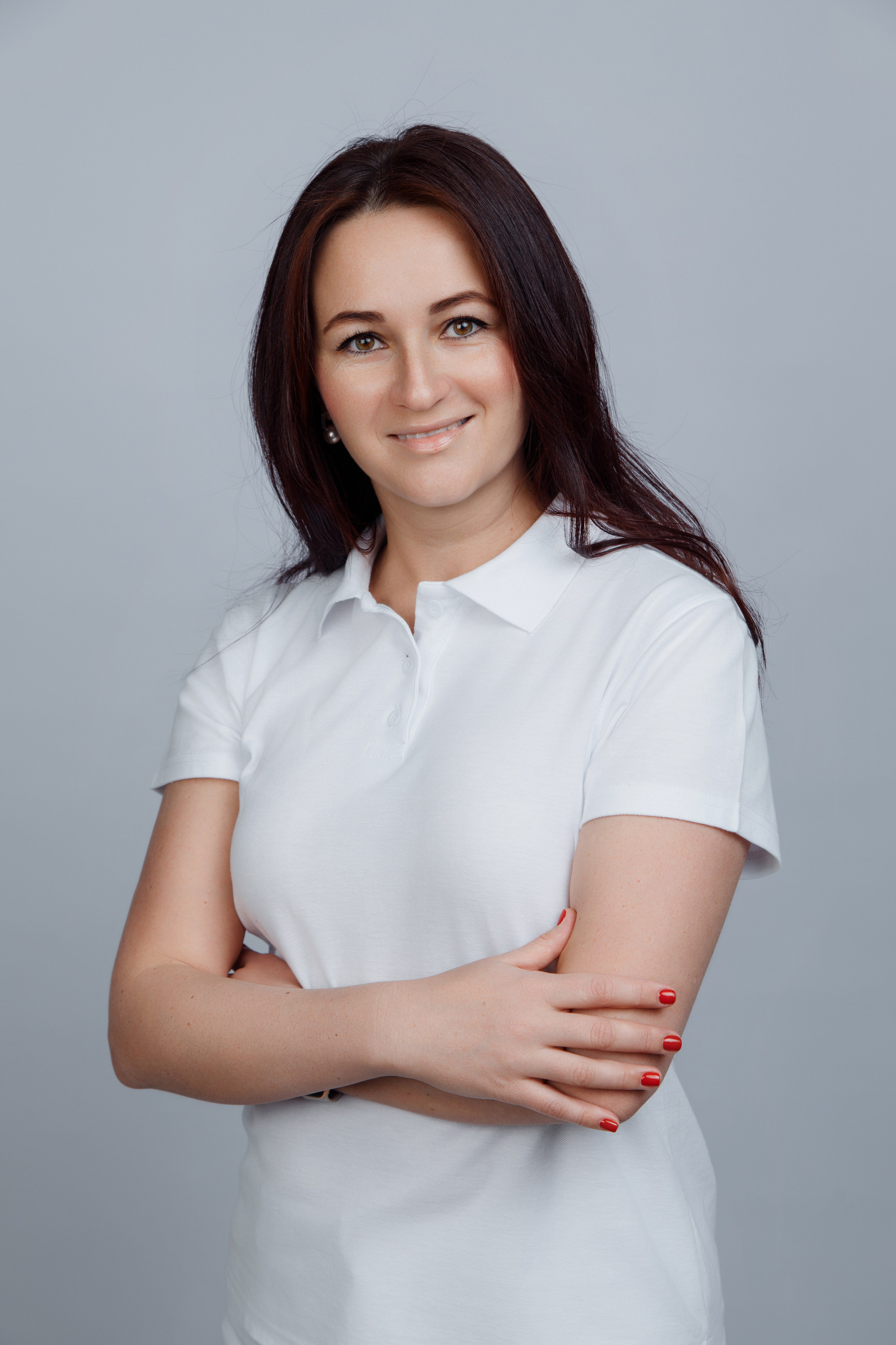 Портрет старшей медсестры стоматологического кабинета в медицинском халате на белом фоне.