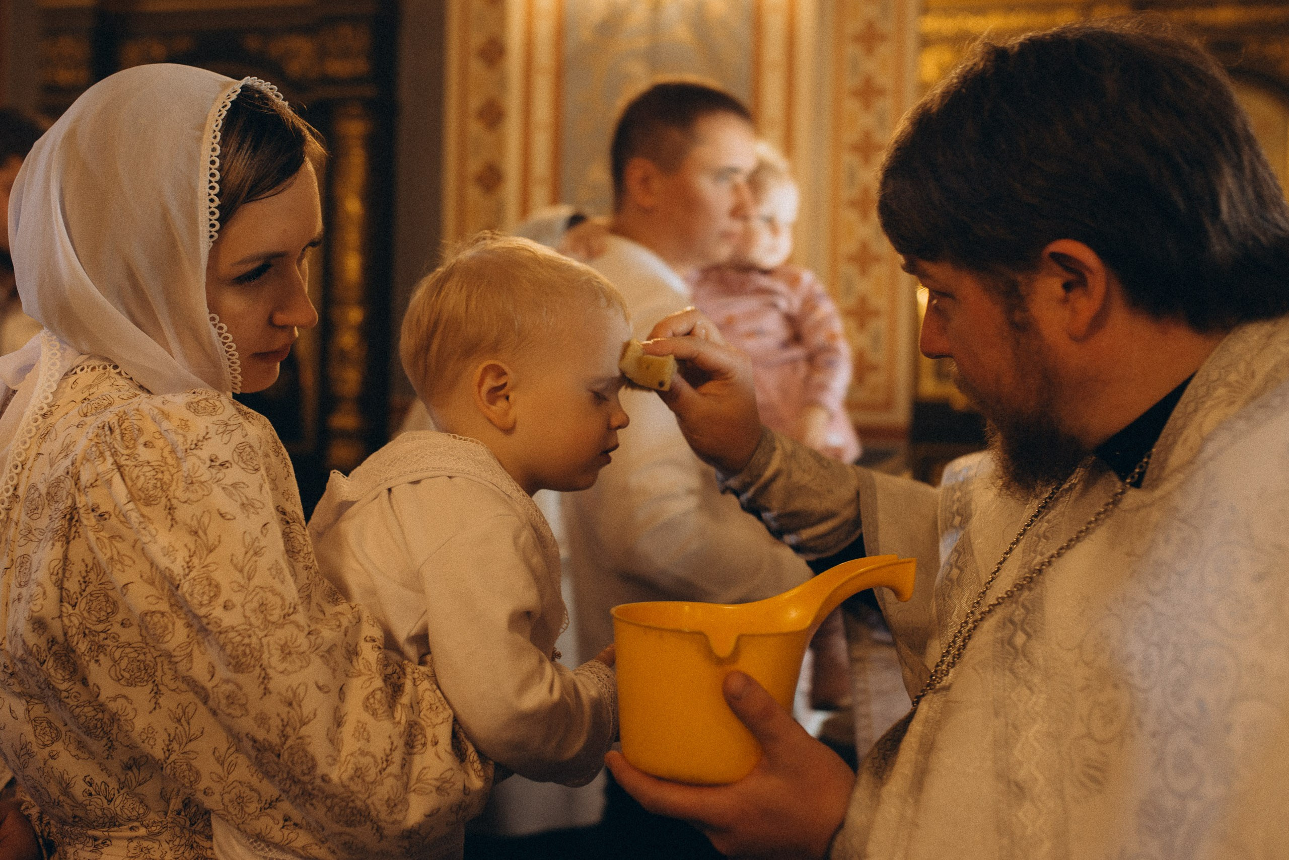 Момент таинства Миропомазания, священник и ребенок в церкви, съемка крещения в Новосибирске