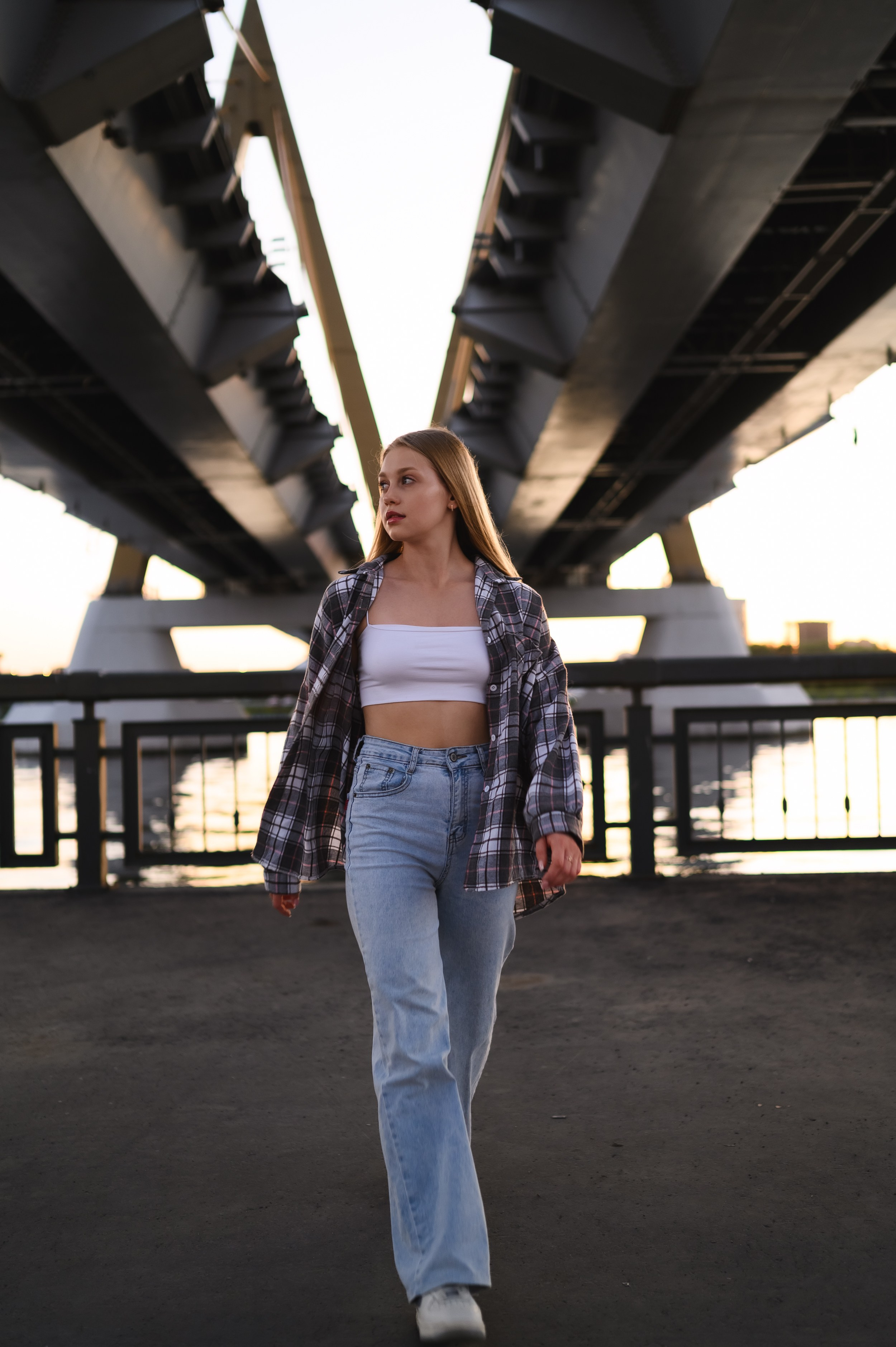 Естественный образ молодой девушки на фоне городской набережной Казани в мягком закатном свете