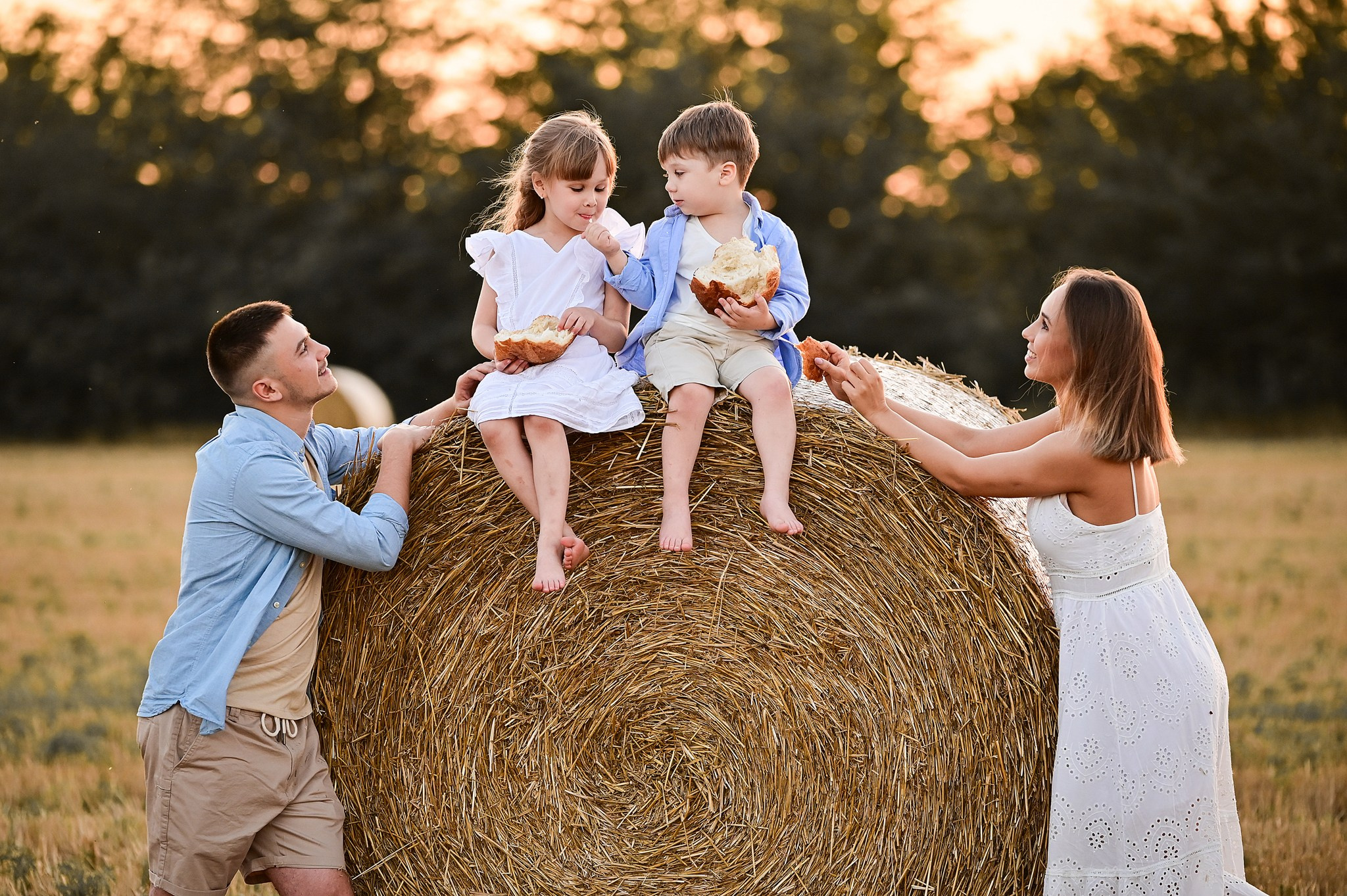 Летняя семейная фотосессия на фоне заката в поле