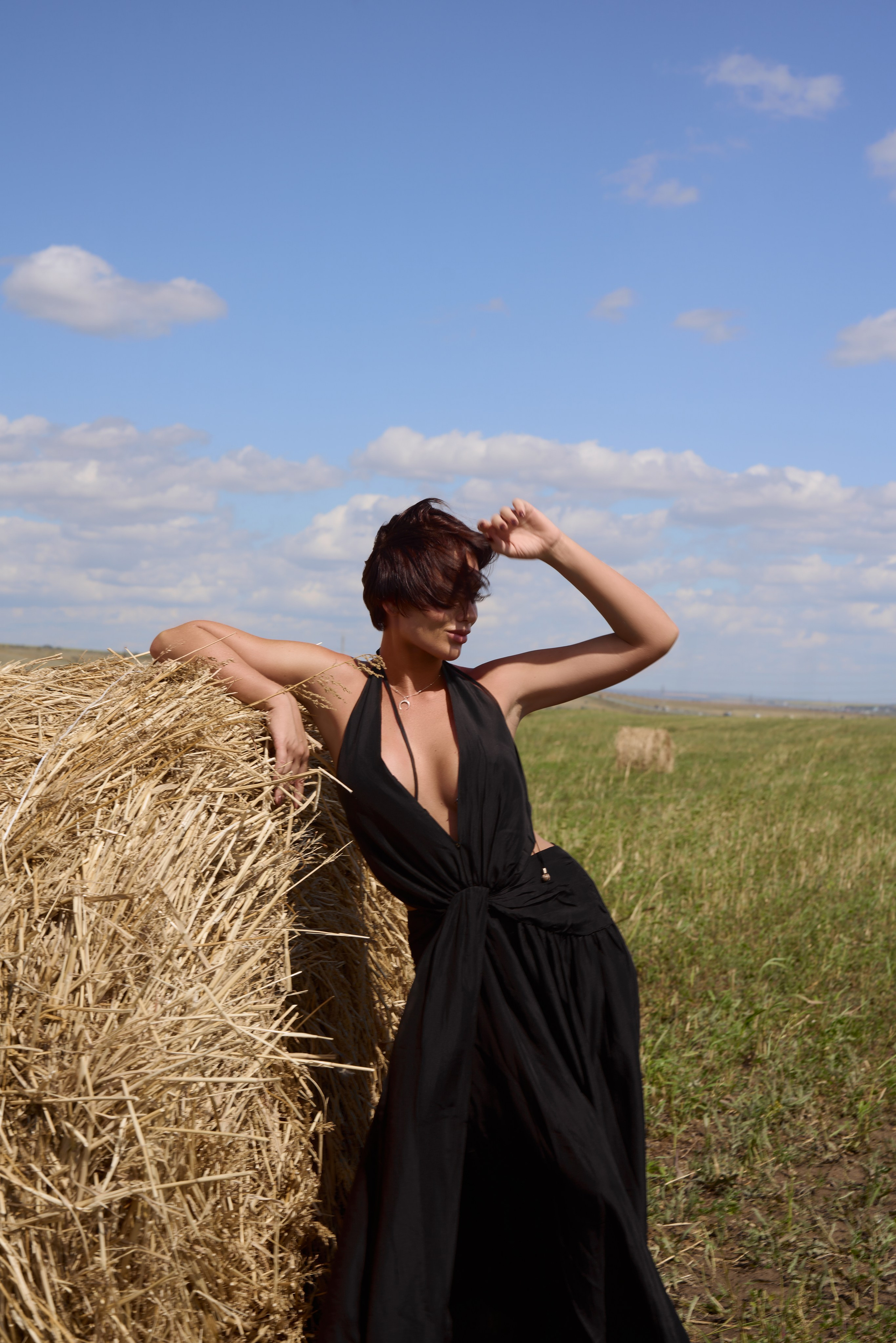 На этом фото с прогулочной фотосессии прекрасная девушка в развевающемся черном платье. Снято в полях Саратова со стогами сена. Фотограф Саратов - Москва