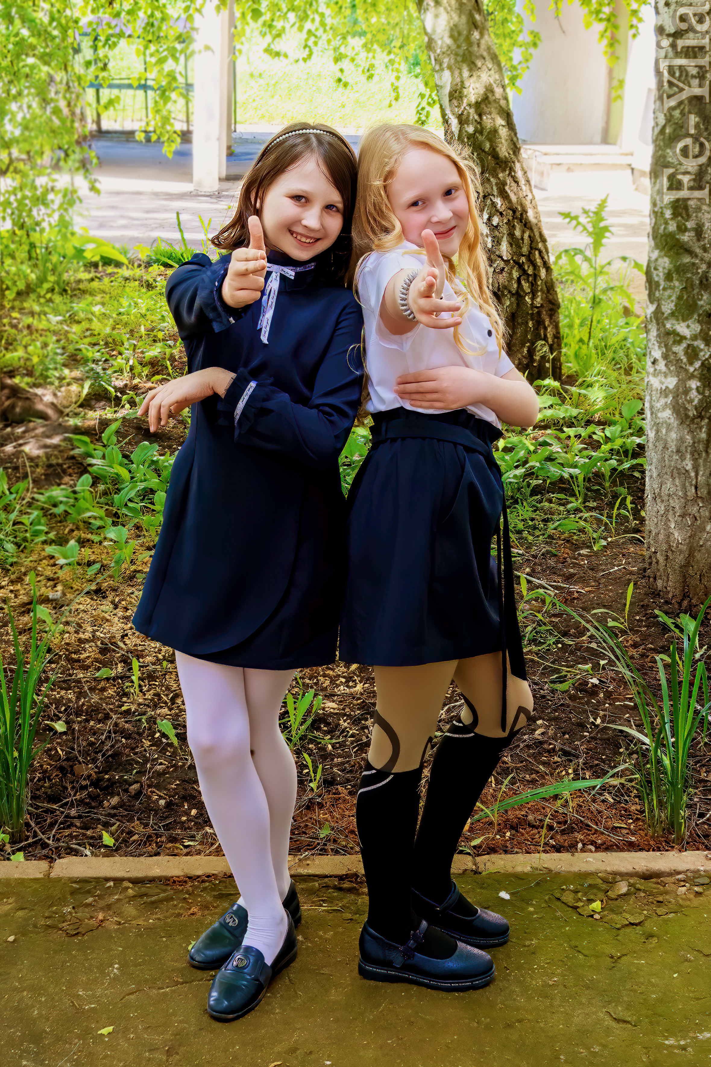 девочки позируют на школьном дворе