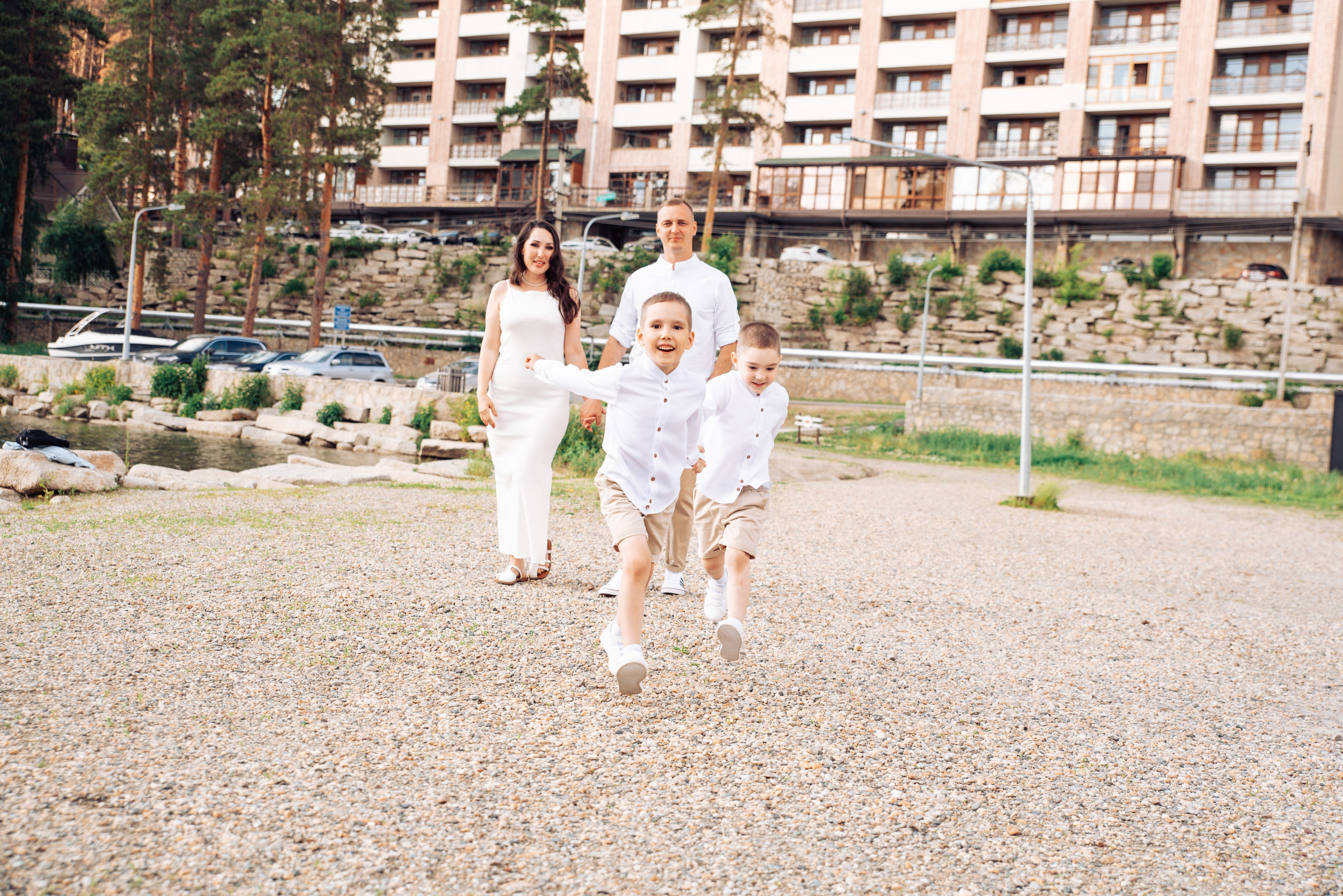 Семейная прогулка летом на берегу озера по пляжу