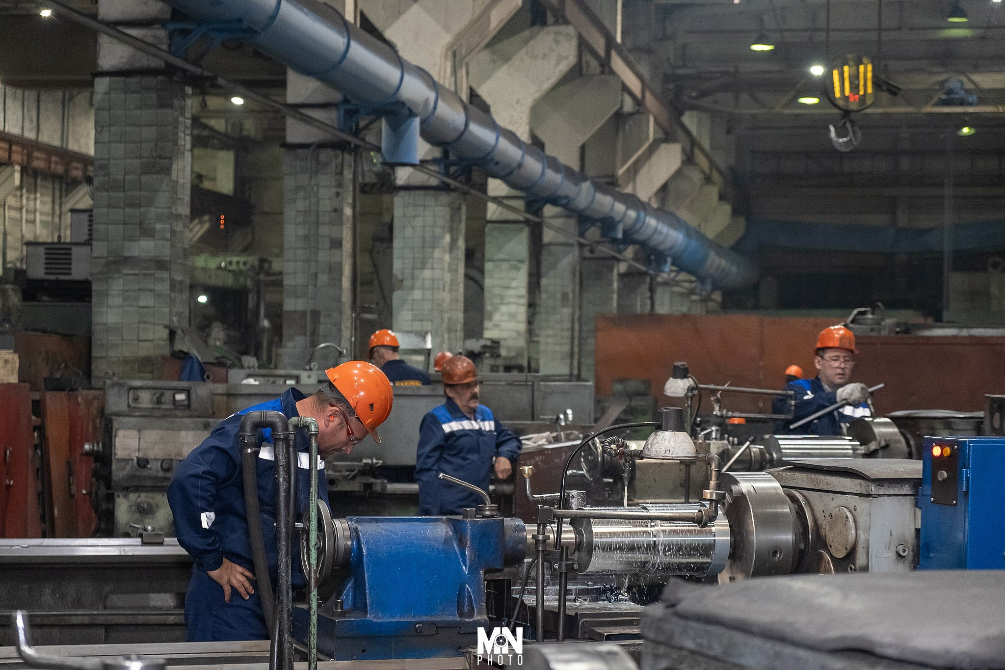 Токарь контролирует систему охлаждения станка во время работы. Фотограф Никита Максимов. Междуреченск.