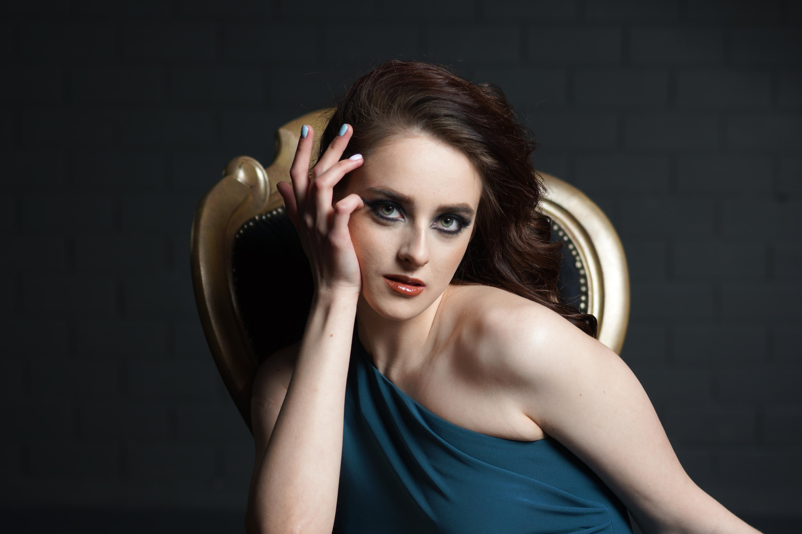 Портрет девушки с каштановыми волосами в темно зеленом платье.