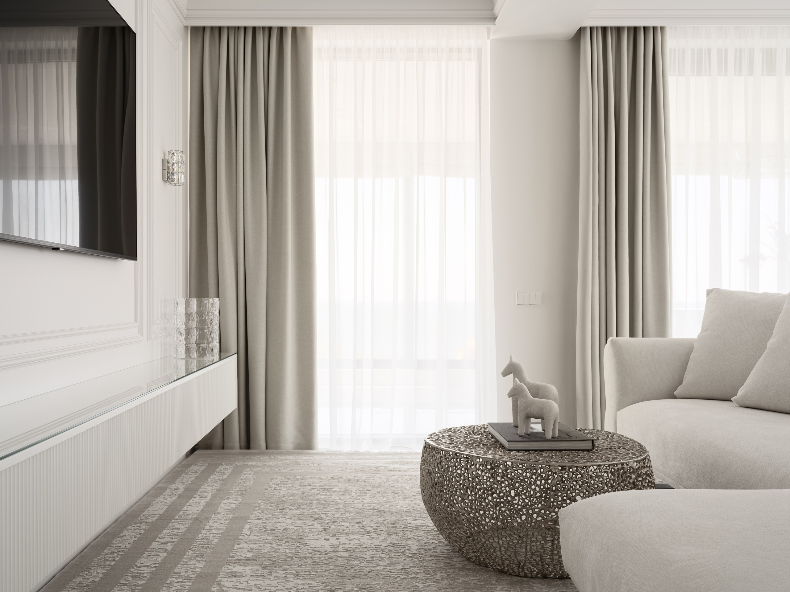 Уютный уголок гостиной с диваном, круглым резным кофейным столиком и настенным ТВ, акцент на текстурах и мягком естественном свете — современный дизайн интерьера Алёны Боярской, стилист Наталья Якушева, фотограф Сергей Денисенко.