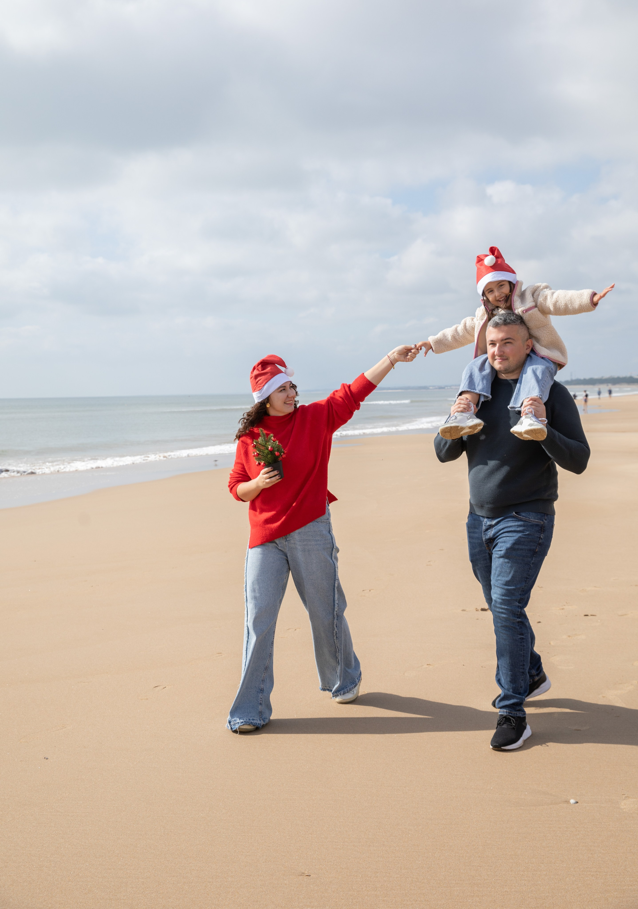 Dad carrying his daughter on his shoulders, both laughing under the sun