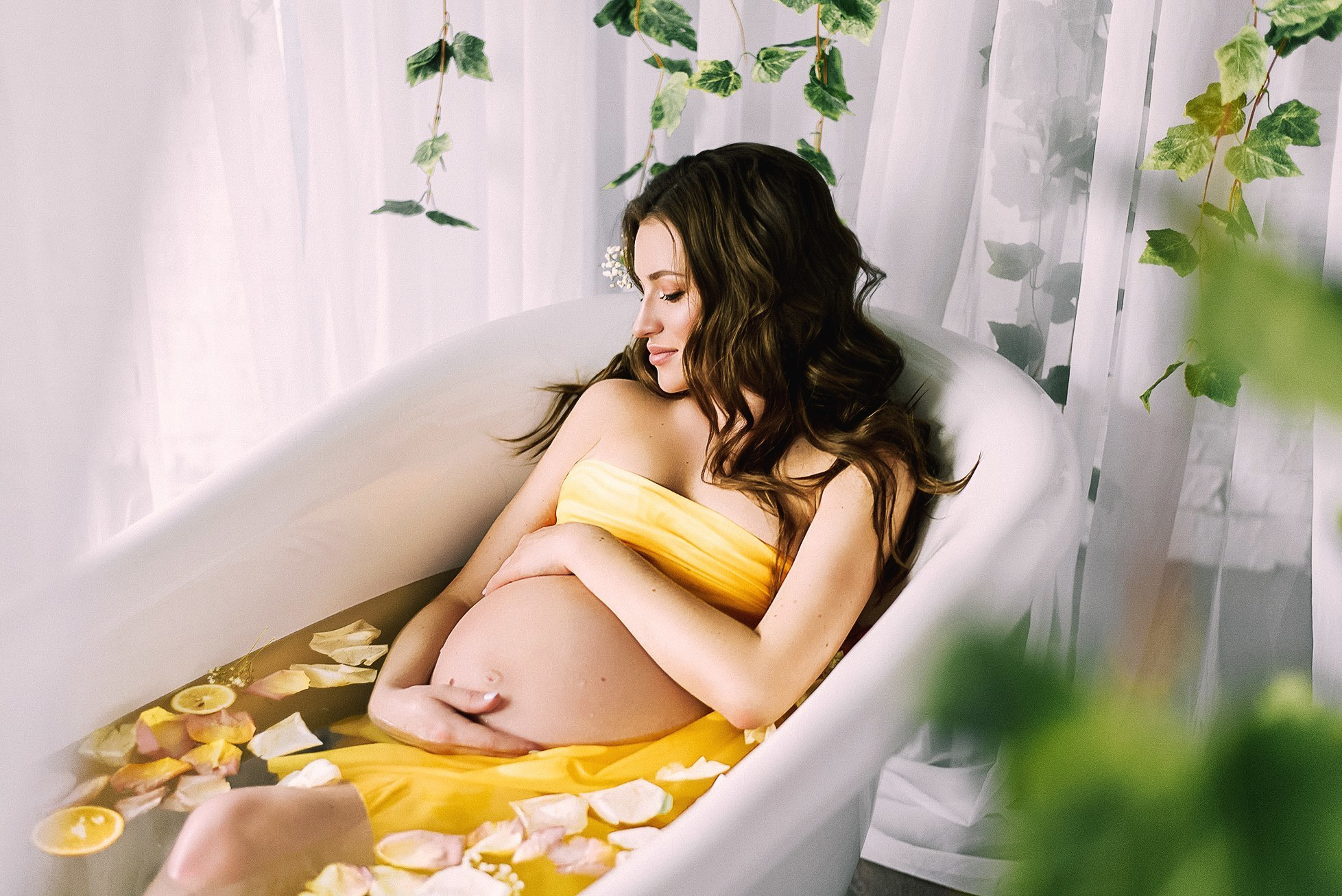 Съемка беременной девушки в ванной с цветами и лимонами