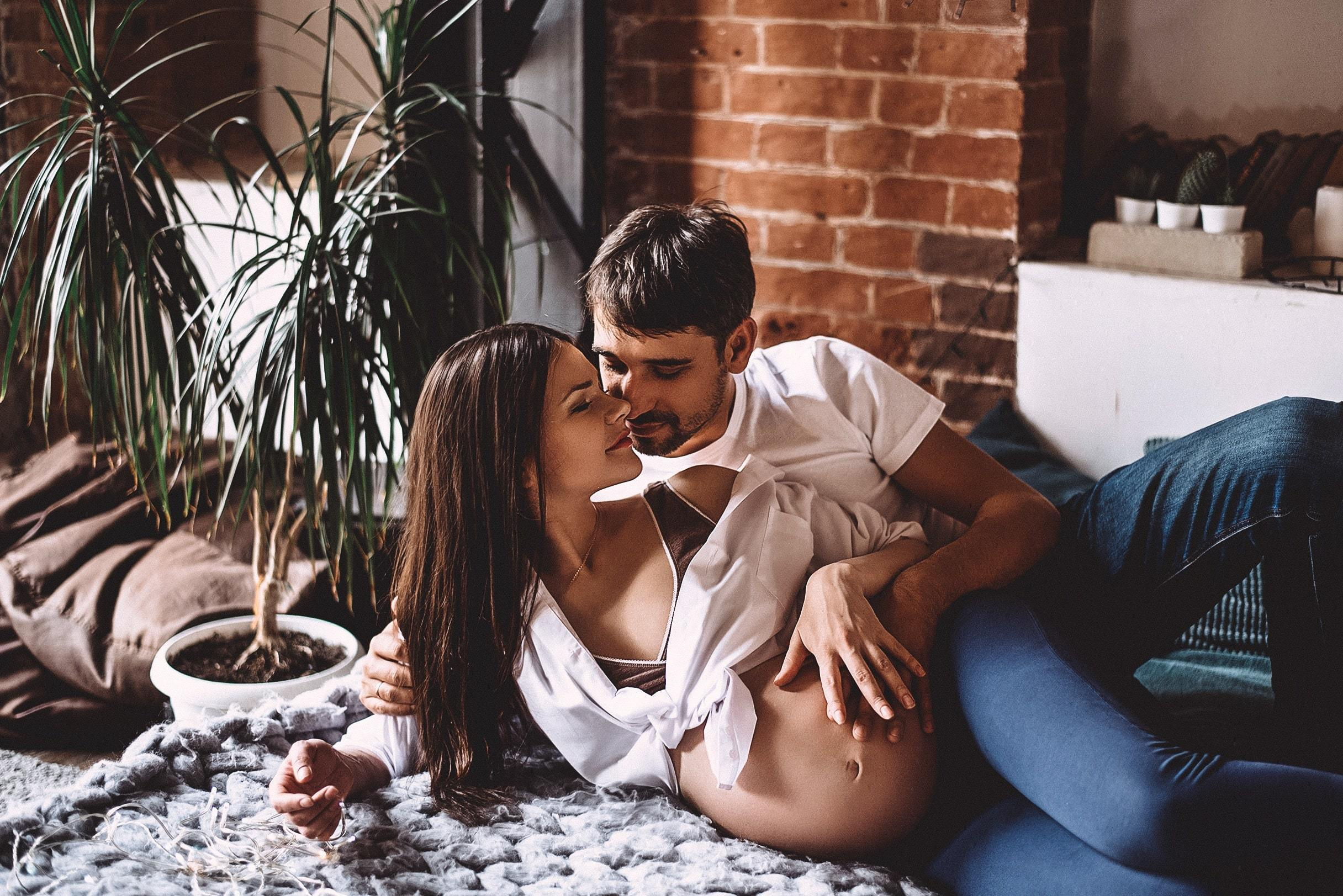 Съемка беременной девушки с мужем у цветка