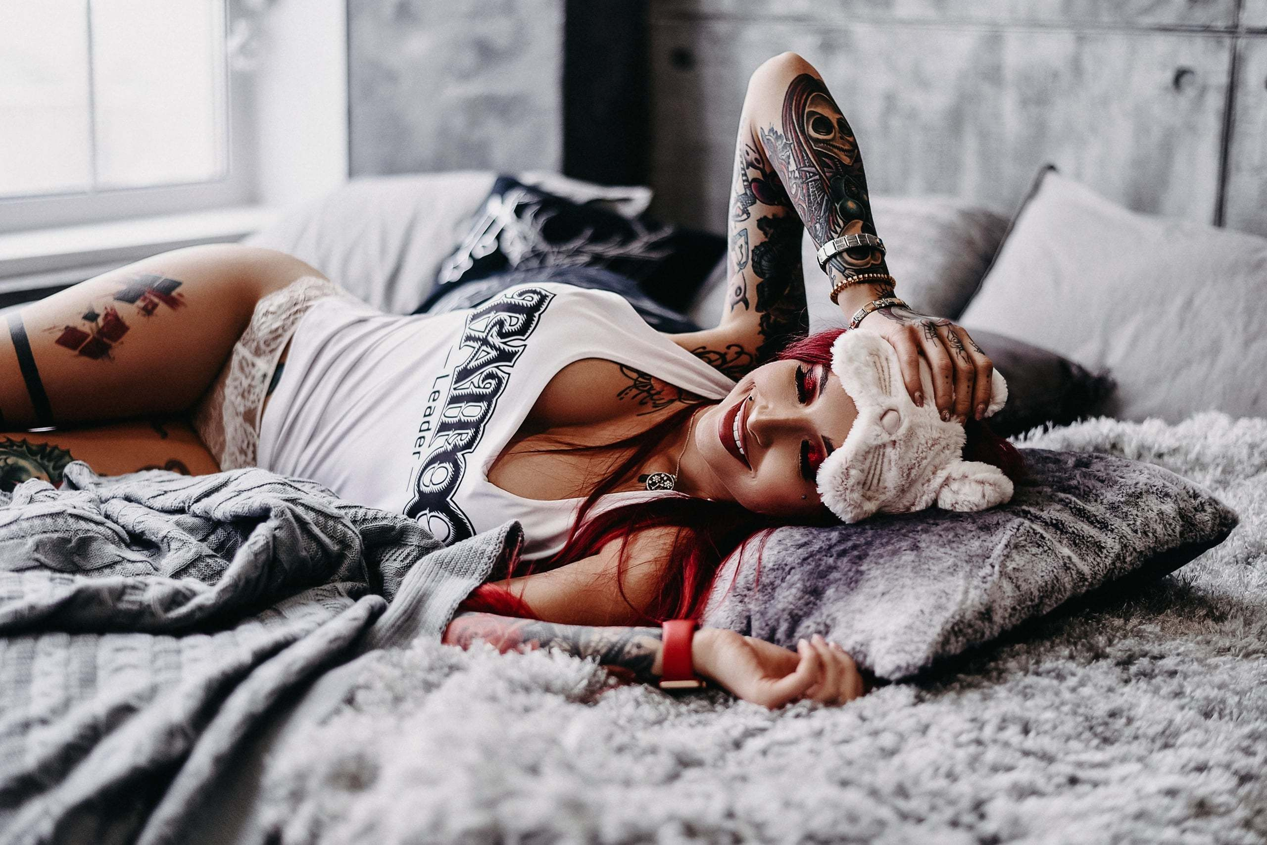 Фотосессия в студии девушка с тату лежит на кровати