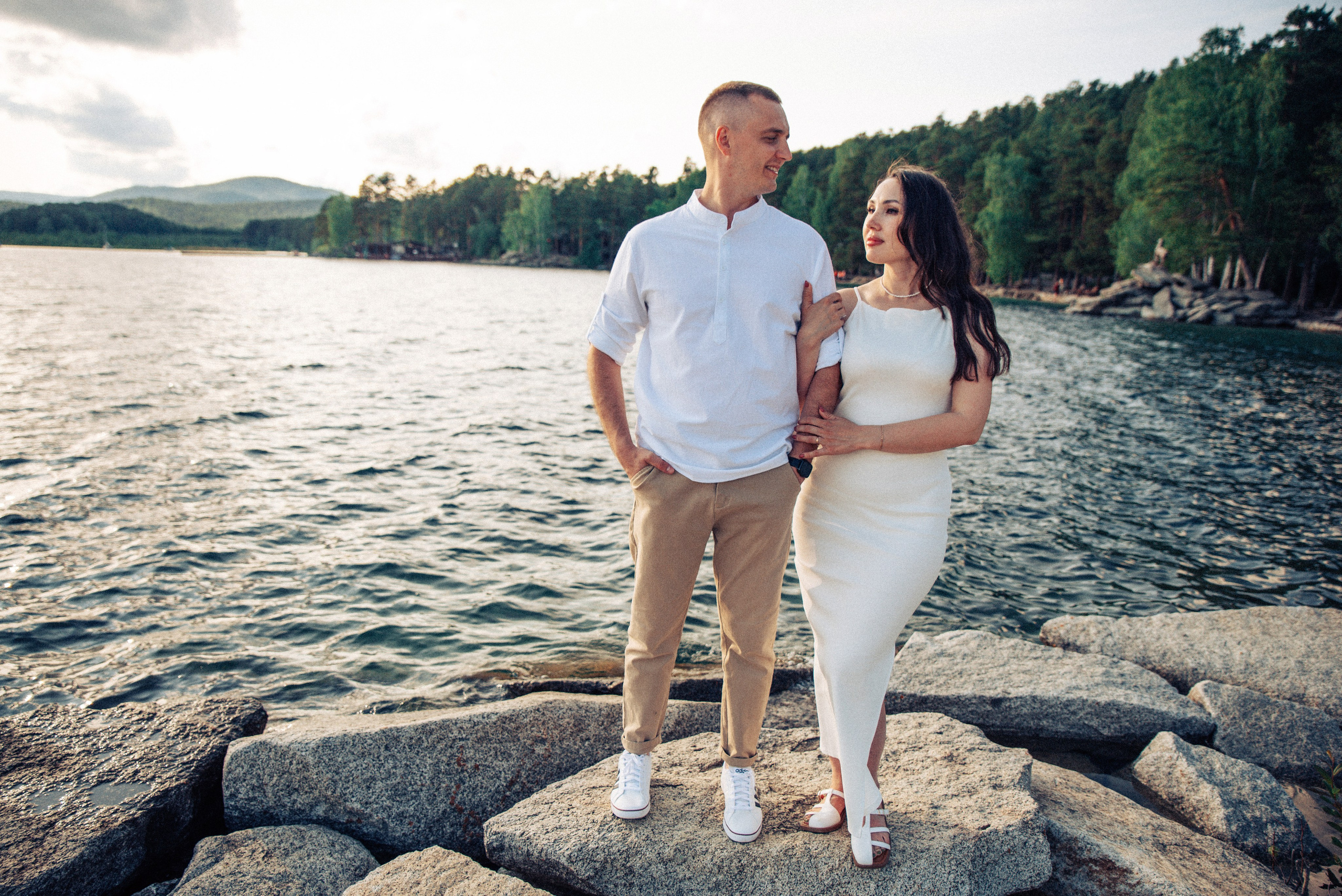 Семейная прогулка летом на берегу озера по пляжу